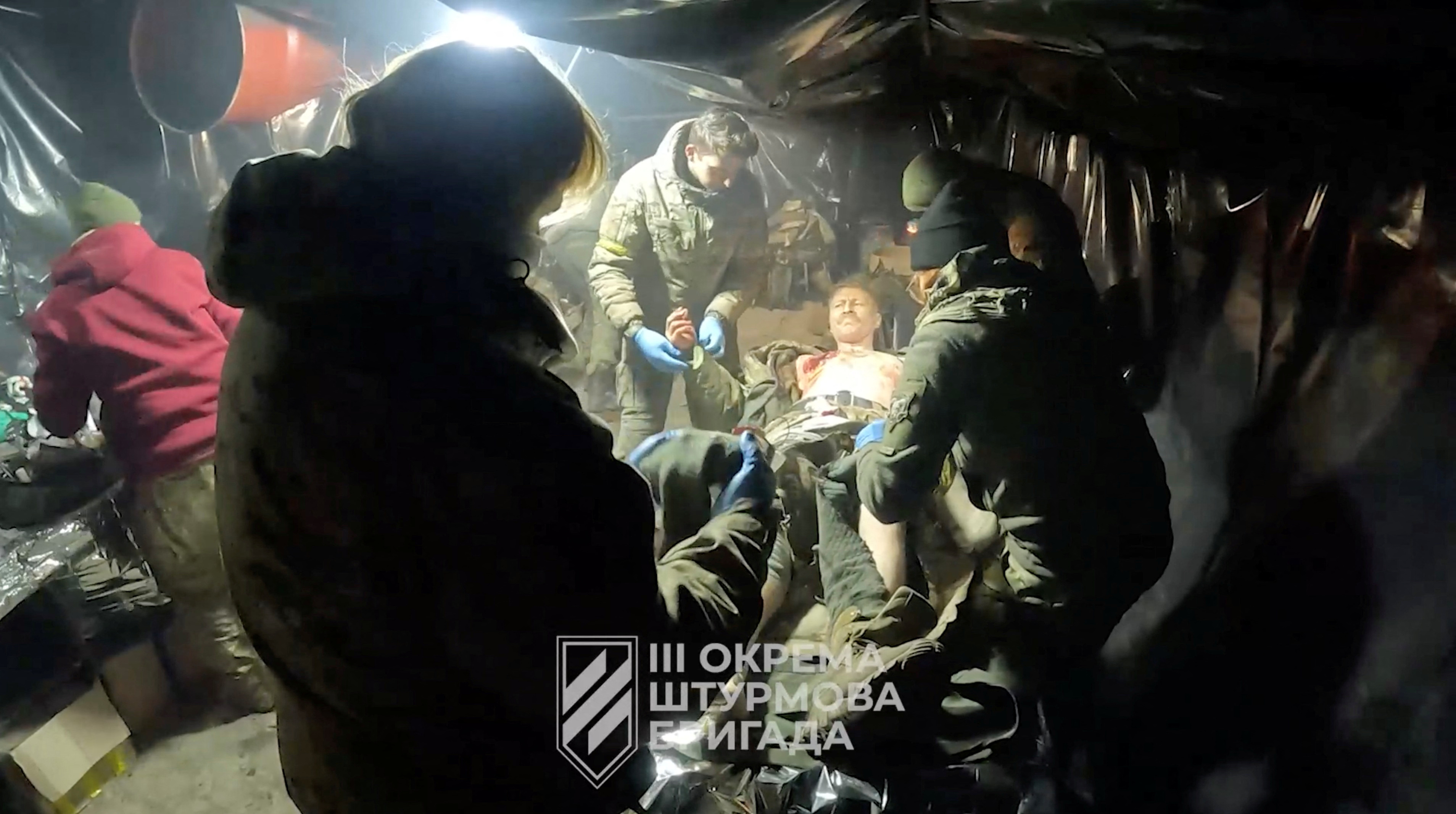 An injured Ukrainian soldier is helped in a location given as Avdiivka, Donetsk Region, Ukraine, in this screen grab taken from a video released February 16, 2024. 
