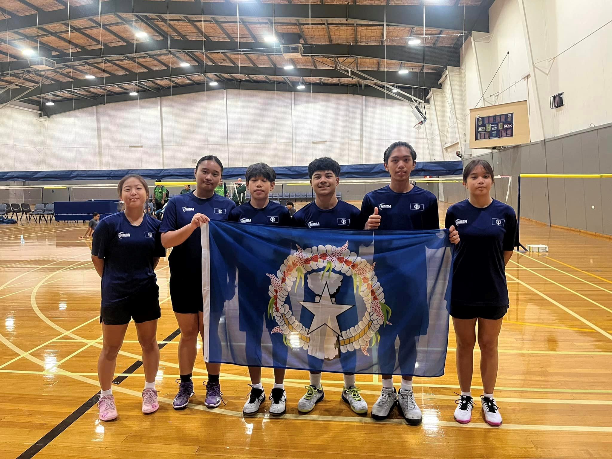 From left, Lina Tsukagoshi, Shaina Malonzo, Evan Seguritan, Sernantie Jimenez, Marlon Bautista, and Genelyn Lansangan pose with the NMI flag before starting their training camp at the Badminton Geelong in Victoria, Australia on Wednesday.