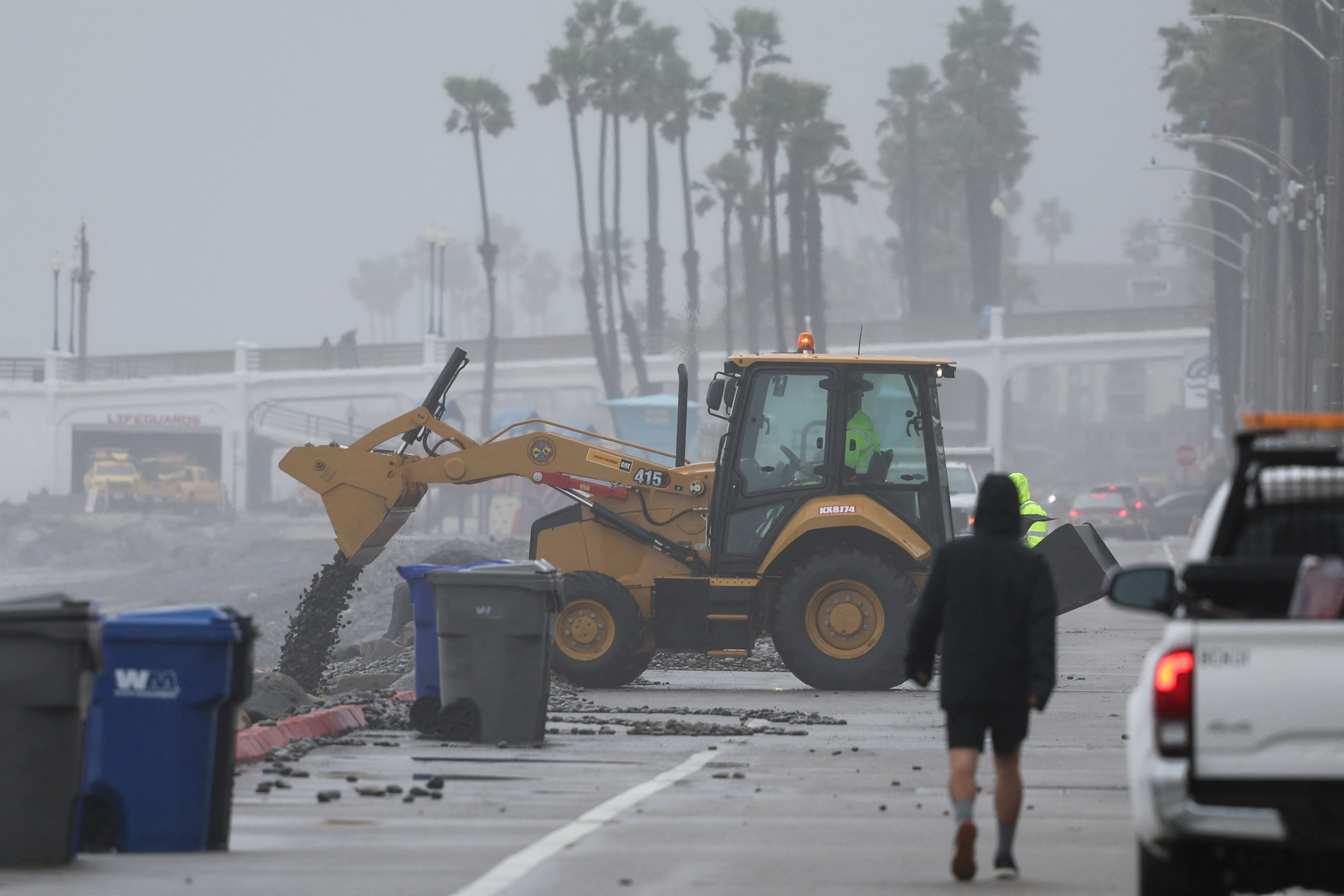 Workers begin to clean up debris from a storm that continues to impact Oceanside, California, U.S., February 6, 2024. 