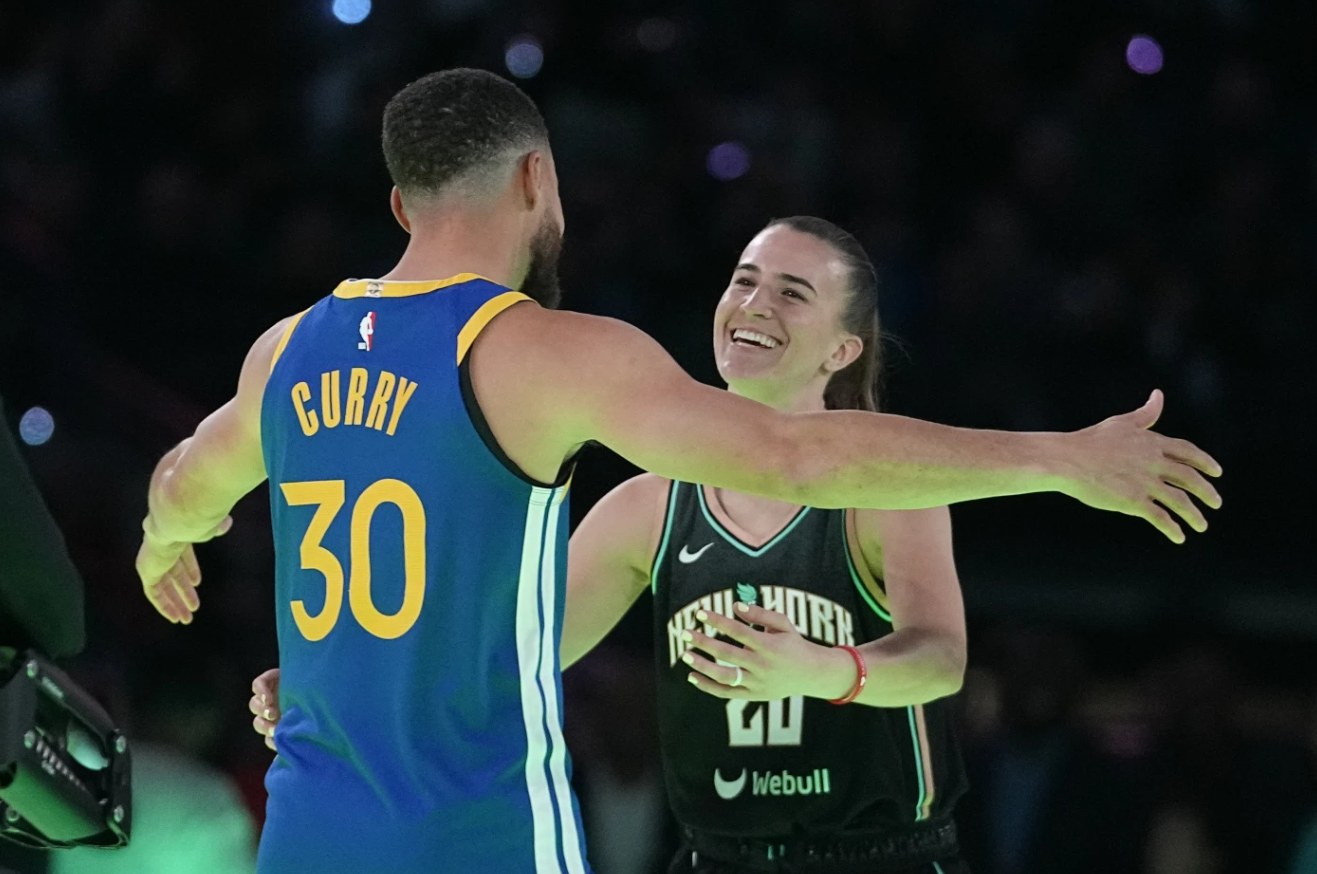 Golden State Warriors guard Stephen Curry hugs New York Liberty guard Sabrina Ionescu after Curry won their competition at the NBA basketball All-Star weekend, Saturday, Feb. 17, 2024.