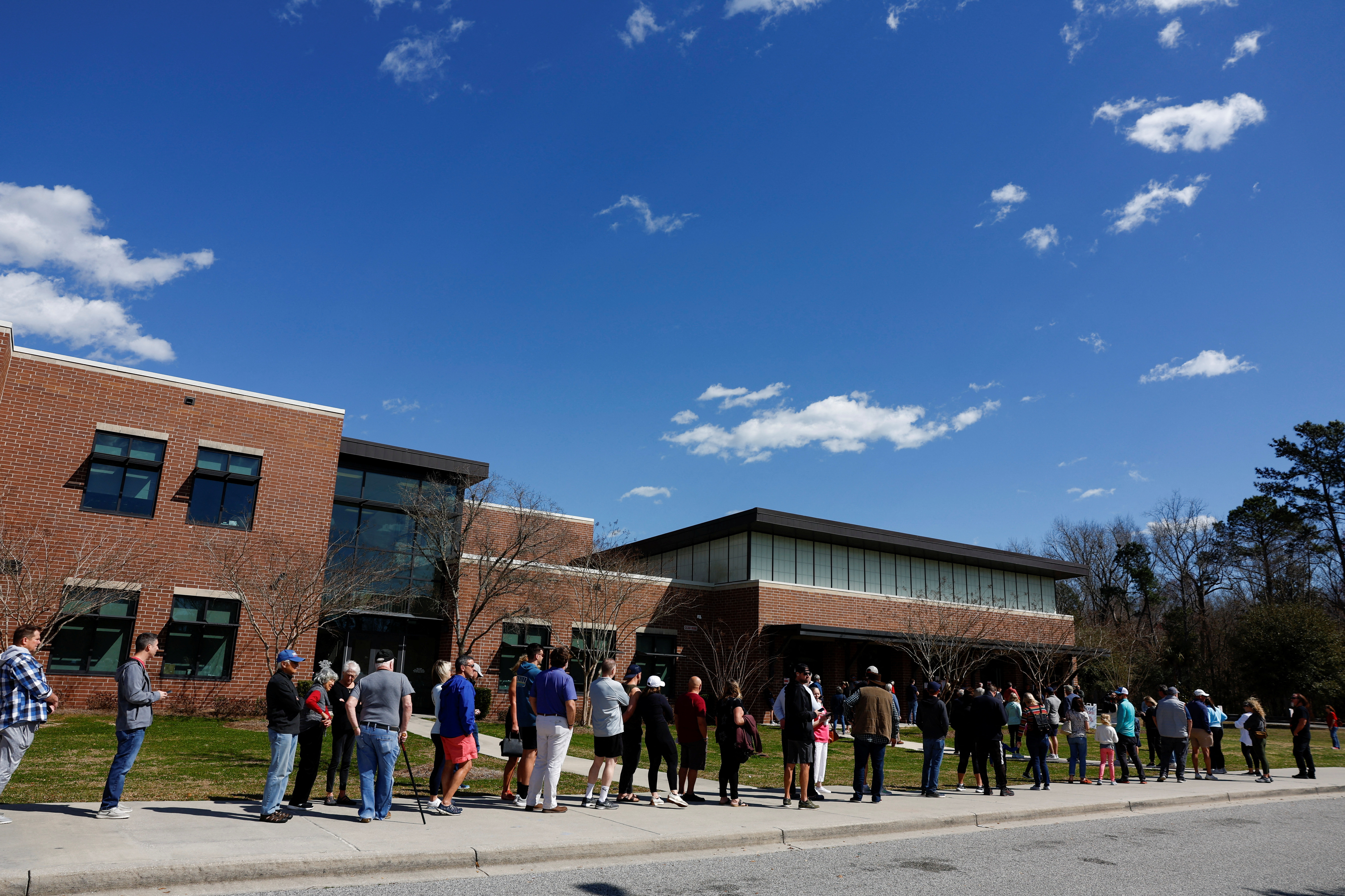 People stand in line to cast their votes in the South Carolina Republican presidential primary election, at the Jennie Moore Elementary School, in Mount Pleasant, South Carolina, U.S., February 24, 2024. 