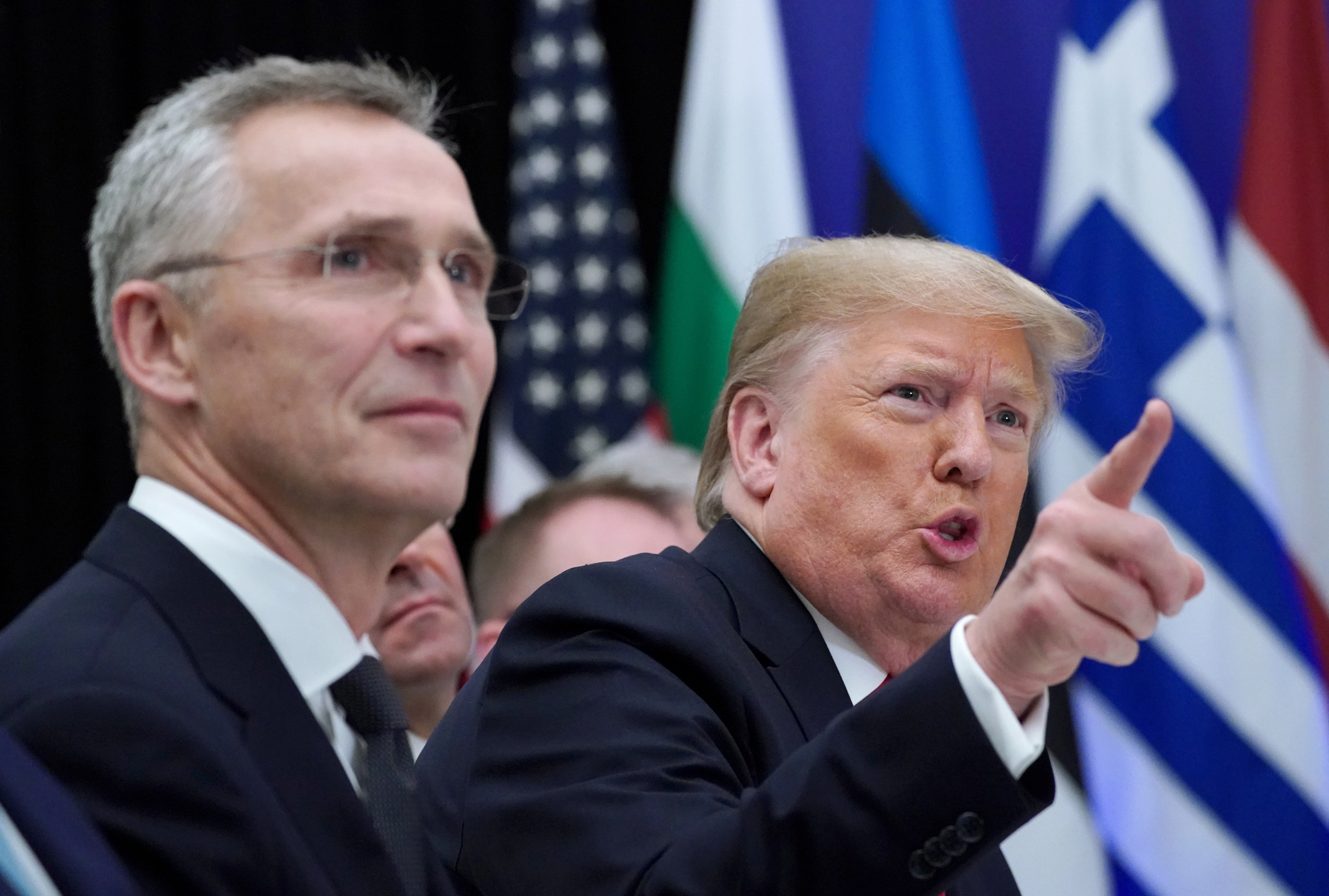 U.S. President Donald Trump gestures next to NATO Secretary General Jens Stoltenberg as they attend a working lunch during the NATO leaders summit in Watford, Britain, December 4, 2019. 