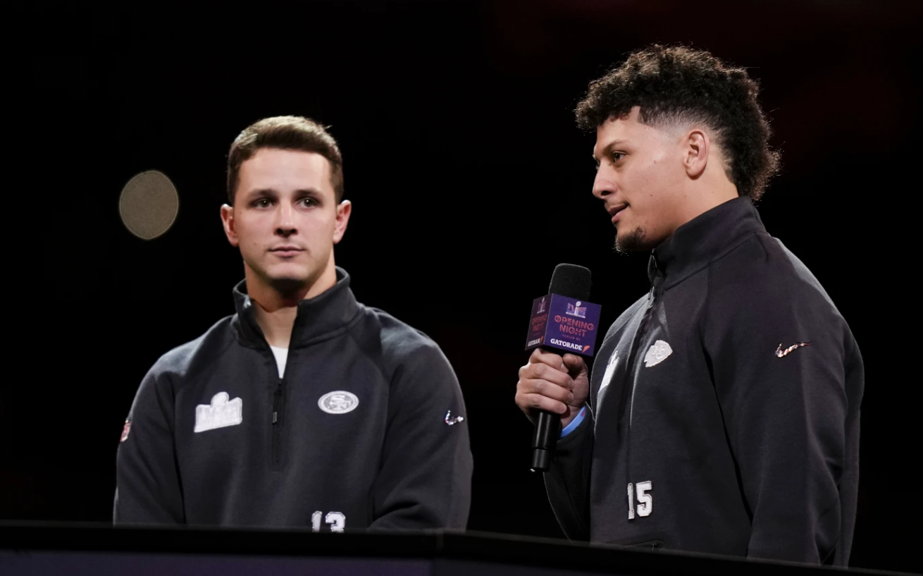 Kansas City Chiefs quarterback Patrick Mahomes, right, speaks to the media as his San Francisco 49ers counterpart, Brock Purdy, looks on during NFL Super Bowl 58 opening night Monday, Feb. 5, 2024, in Las Vegas. The Chiefs will face the 49ers on Sunday.