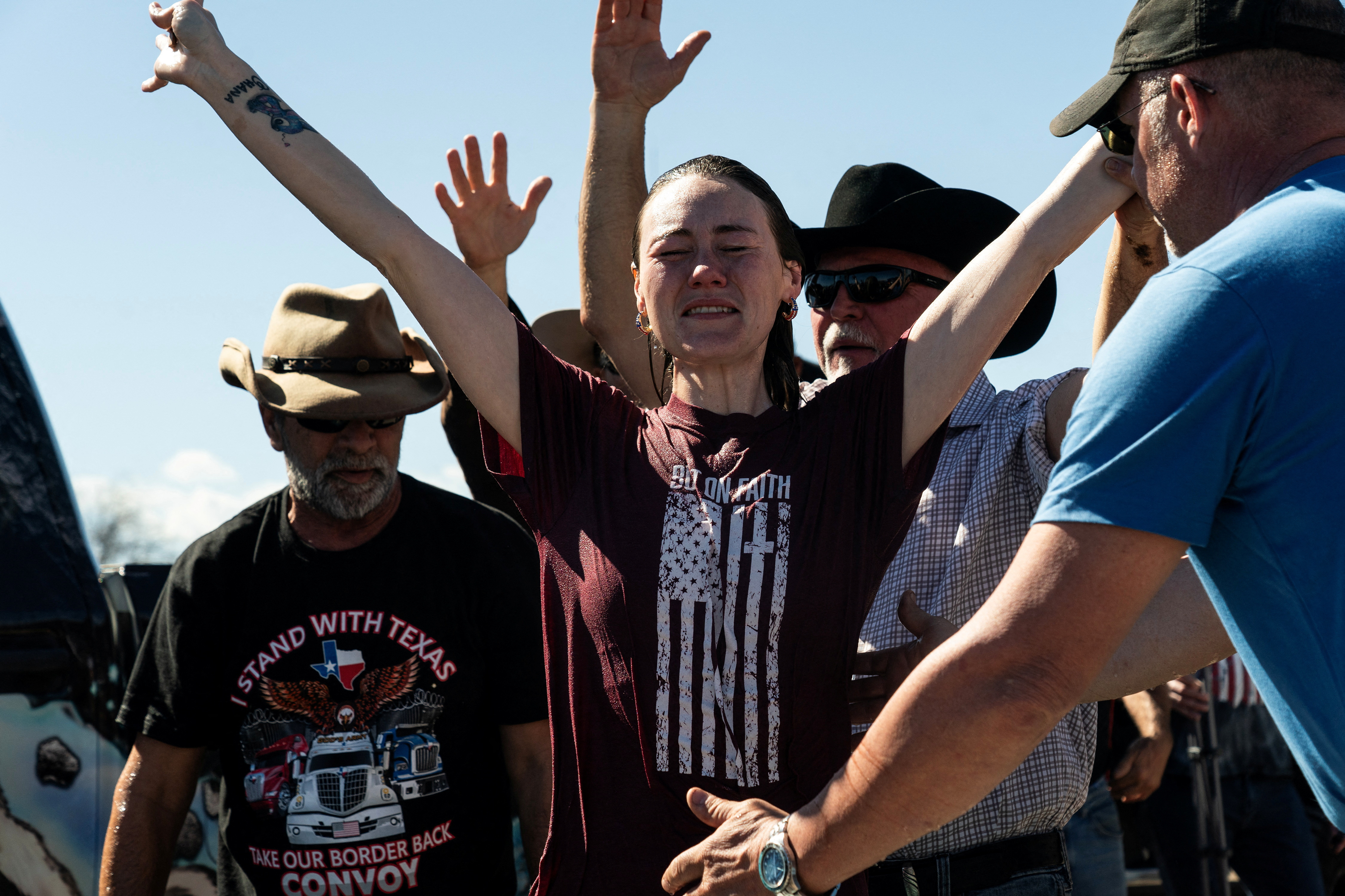 Felicia Hicks, a participant of 'Take Back Our Border' trucker convoy rally against migrants crossing from Mexico, celebrates after being baptized in a tub filled with water during the event in Quemado, Texas, U.S., February 3, 2024. 