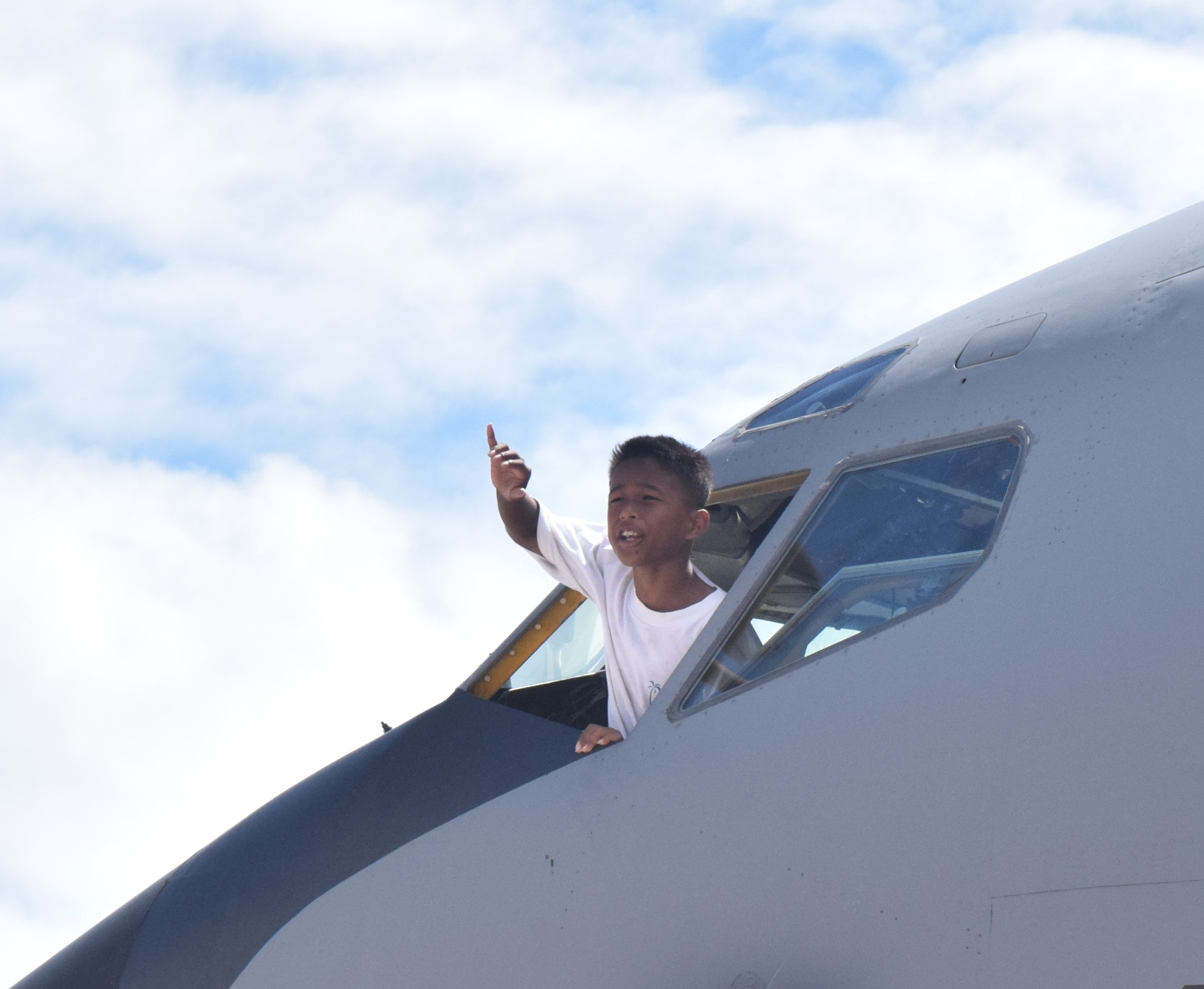 From the cockpit of a KC-135, a boy waves at his friends.