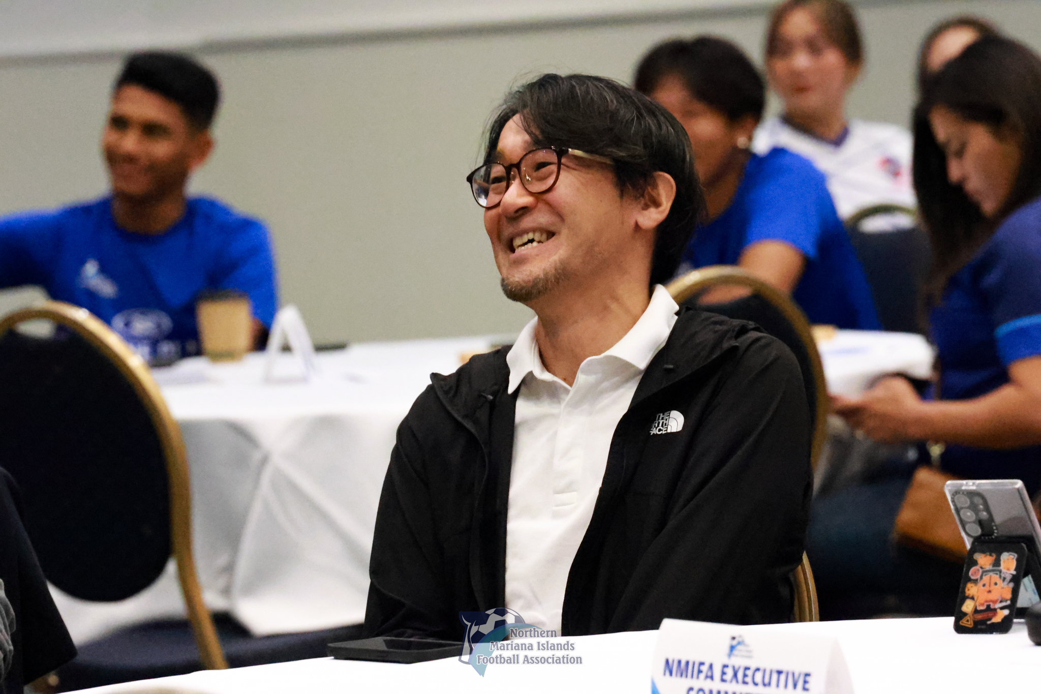 Michiteru Mita smiles as he watches a video tribute in his honor during a farewell luncheon hosted by the Northern Mariana Islands Football Association at the Crowne Plaza Resort Saipan on Saturday