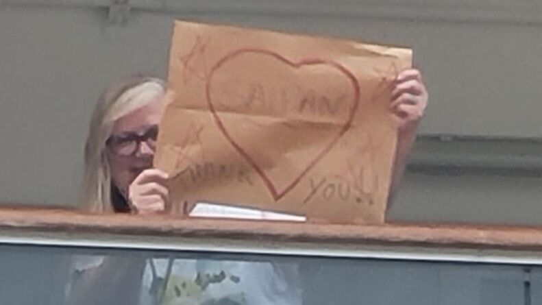 A passenger of MS Zuiderman holds a sign thanking Saipan as the cruise ship departs the island on Monday afternoon.