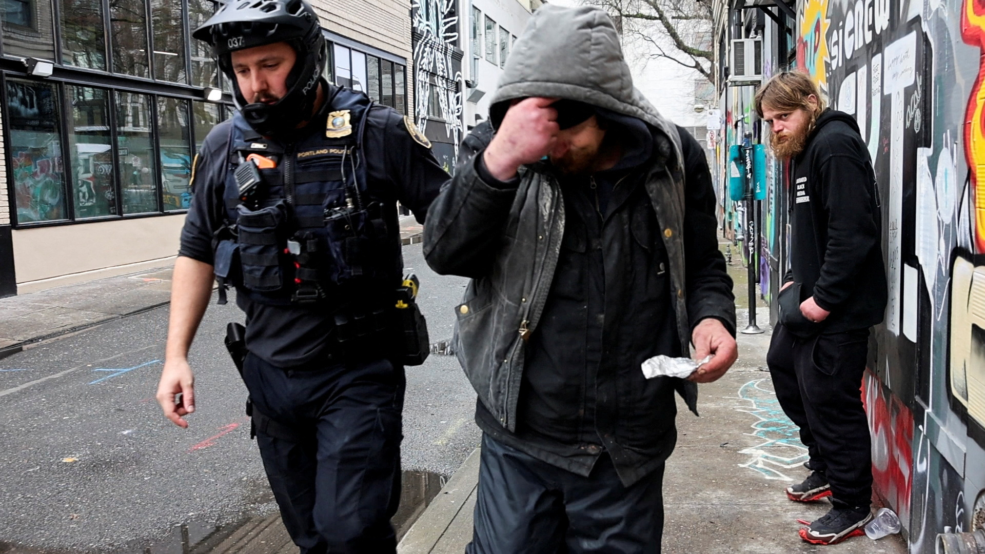 Police officer David Baer pulls a man, who was caught smoking fentanyl, to issue him a citation and to offer him a card that lists a 24-hour treatment hotline which he can call to get his citation dismissed in Portland, Oregon, U.S. February 7, 2024. 