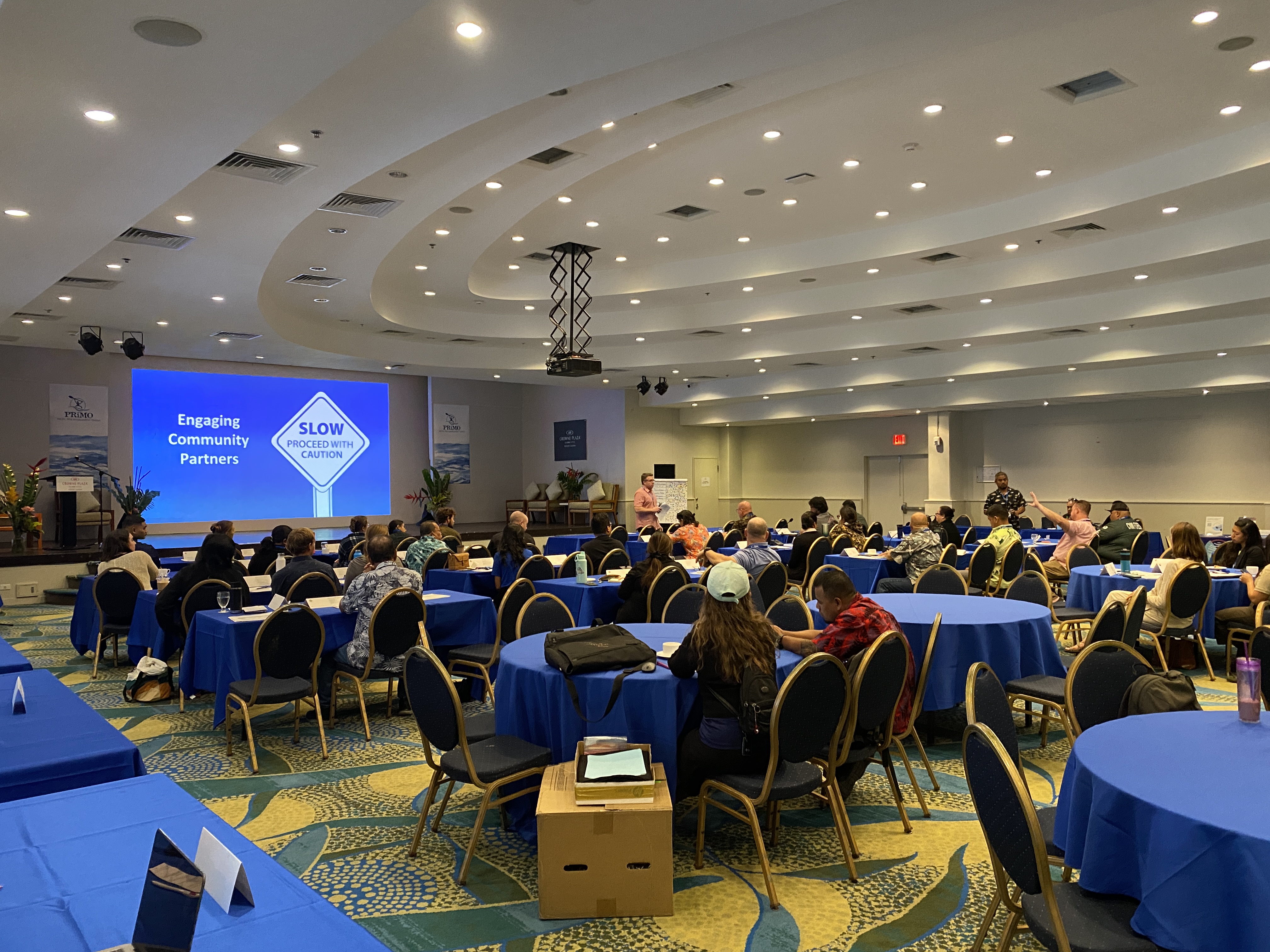 Participants listen to a presentation titled "Planning for Coastal Hazards in the Azucena room of the Crowne Plaza Hotel as part of a pre-conference training for the Pacific Risk Management Ohana conference, which will take place from Feb. 22 to 23. 
