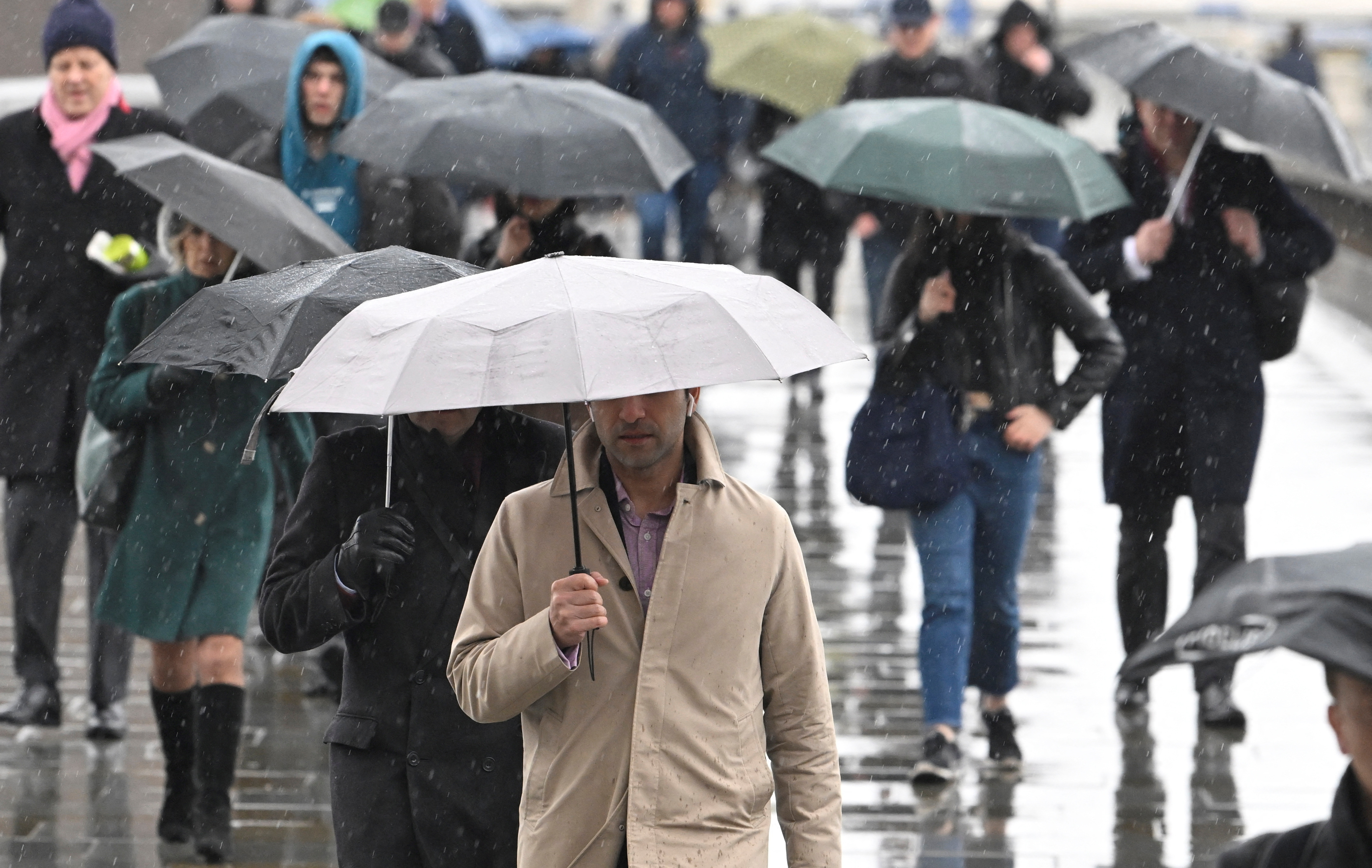 Workers cross London Bridge during the morning rush hour in London, Britain, March 10, 2023. 