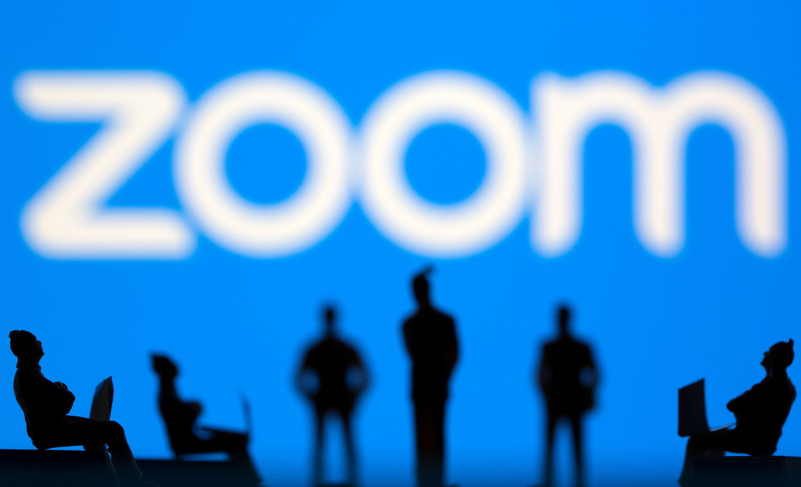 Small toy figures are seen in front of Zoom logo in this illustration picture taken March 15, 2021. 