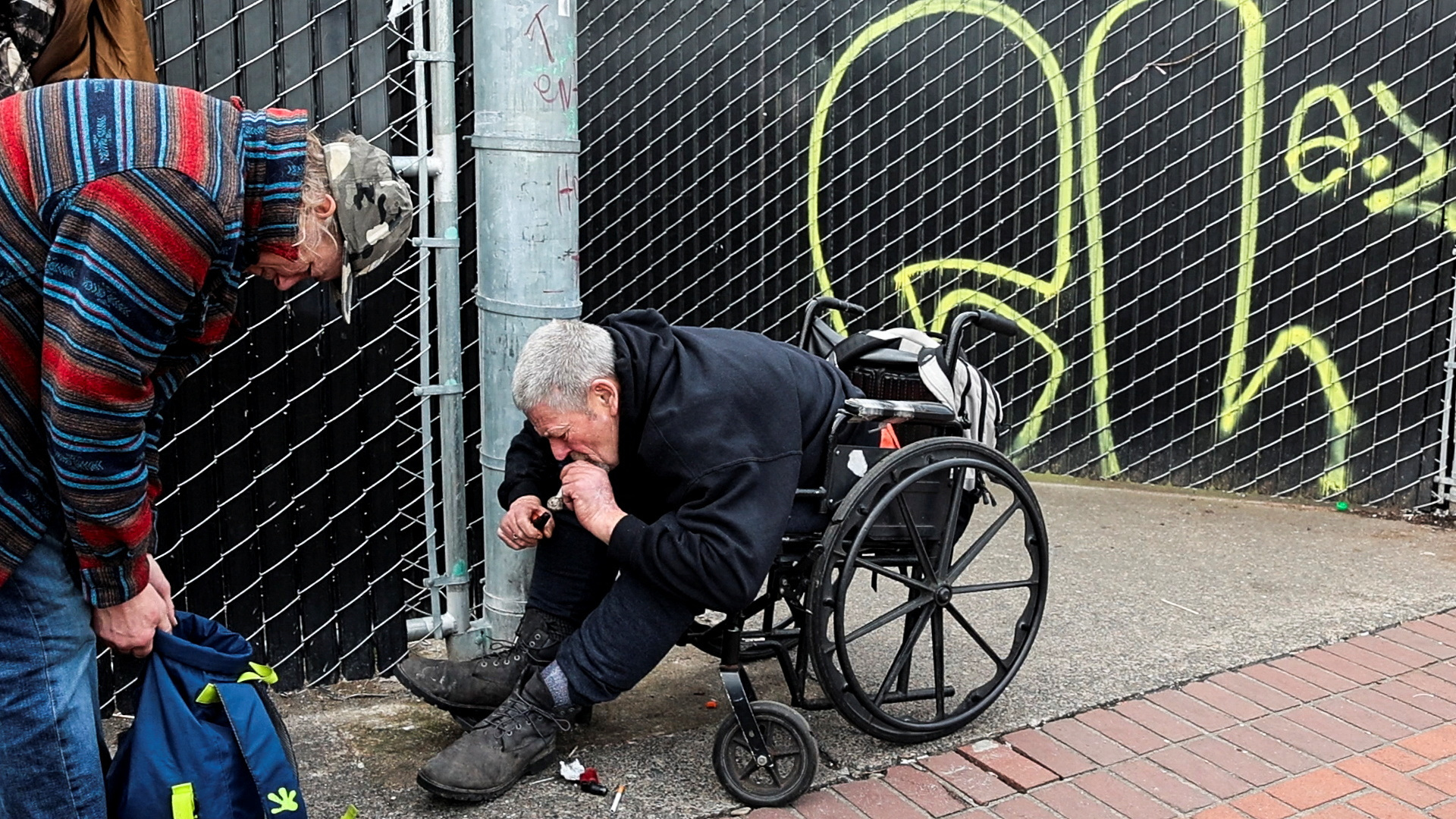 John Hood smokes methamphetamine with a friend outside a homeless shelter in downtown Portland, Oregon, U.S. February 9, 2024. He says he will sometimes smoke methamphetamine after fentanyl as a way to perk himself up. 