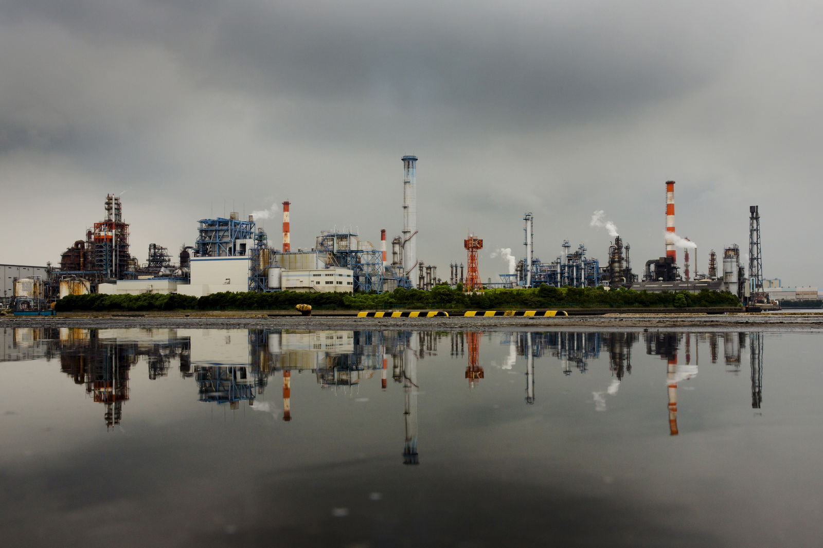 FILE PHOTO: A petrochemical plant is reflected in a puddle at an industrial complex in Kawasaki near Tokyo August 31, 2015. 