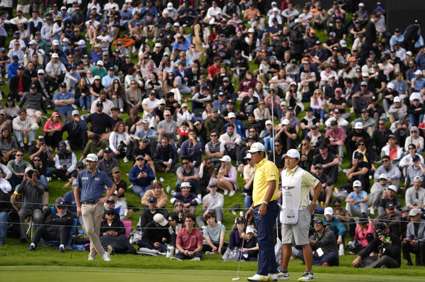 Hideki Matsuyama of Japan and his caddie wait on the 18th green during the final round of the Genesis Invitational golf tournament at Riviera Country Club, Sunday, Feb. 18, 2024, in the Pacific Palisades area of Los Angeles.