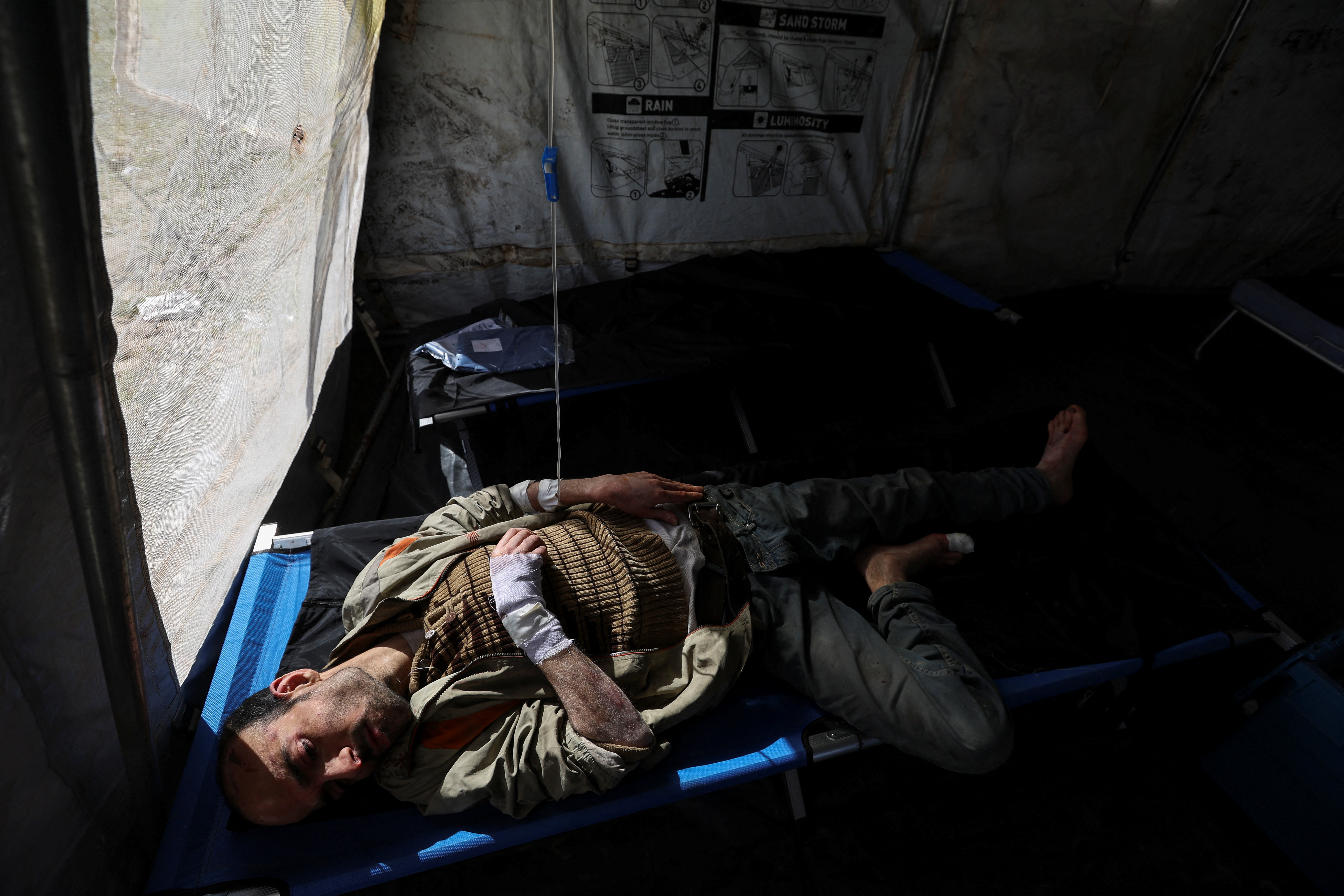 A Palestinian man, wounded in Israeli fire, lies at a medical point formed to get better access to frontlines, amid the ongoing conflict between Israel and Hamas, in Khan Younis in the southern Gaza Strip January 30, 2024. 