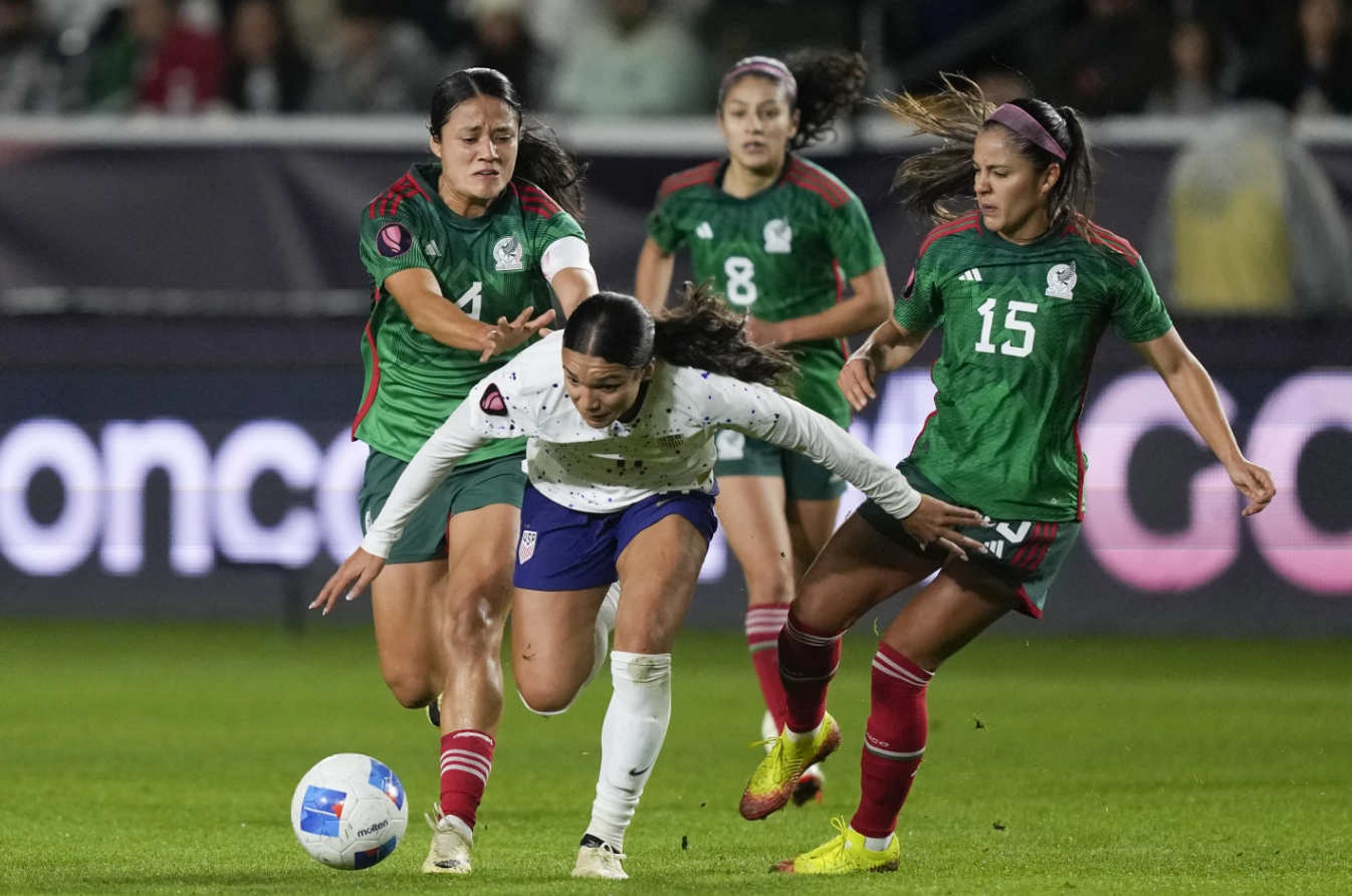 United States forward Sophia Smith, front, falls while vying for the ball against, from back left to right, Mexico defender Rebeca Bernal, midfielder Alexia Delgado and defender Cristina Ferral during a CONCACAF Gold Cup women’s soccer tournament match, Monday, Feb. 26, 2024, in Carson, Calif.