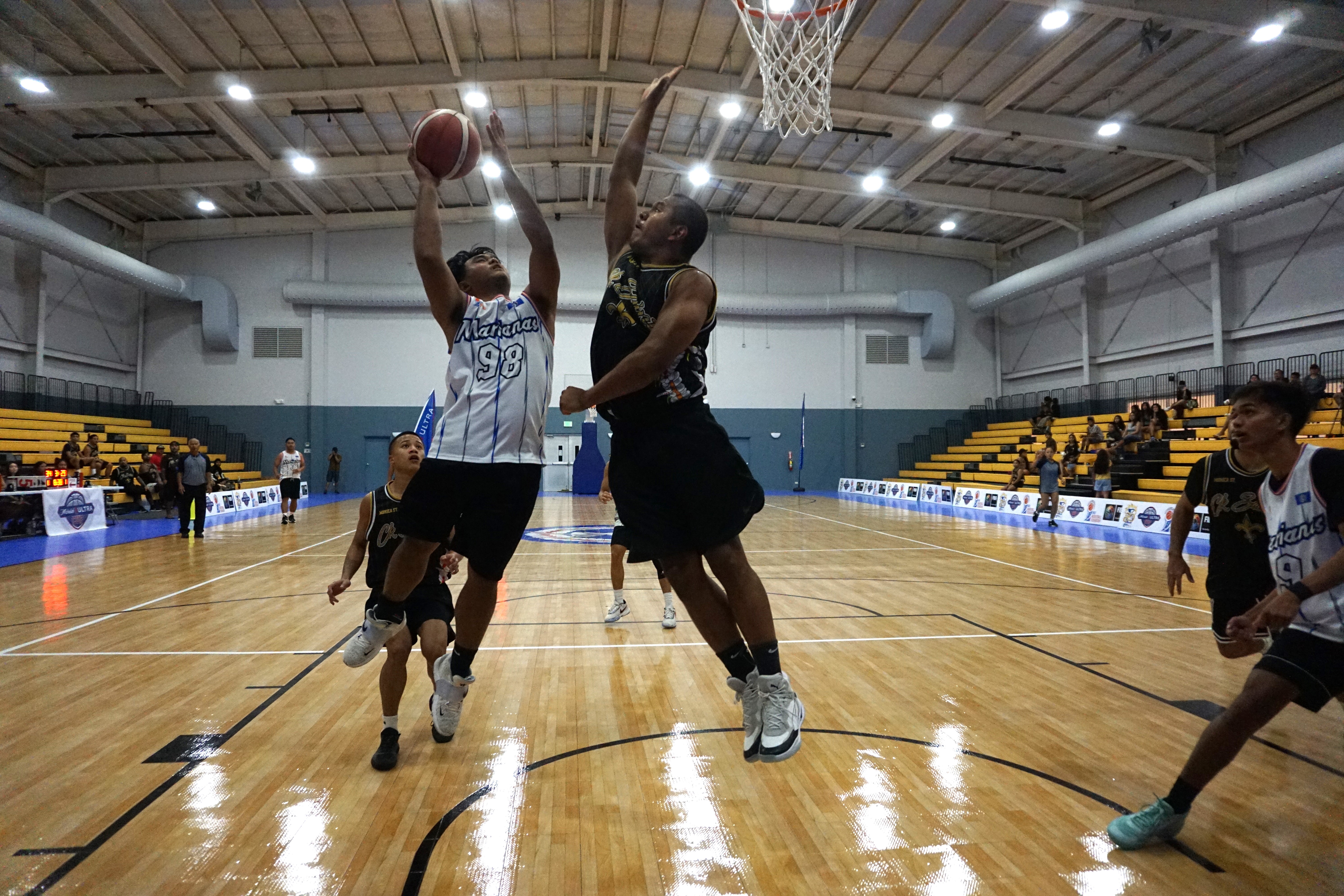 Team Marianas' Greg Sablan goes up for the shot against CK Saint's Melvin Manibusan during the inaugural  Michelob Ultra Cup at the Ada gym last year.