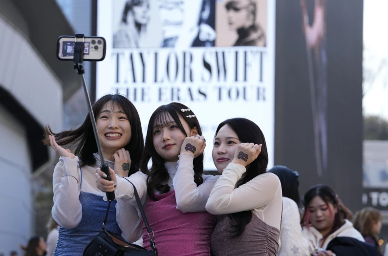 Women pose for a selfie before Taylor Swift’s concert at Tokyo Dome in Tokyo, Saturday, Feb. 10, 2024.