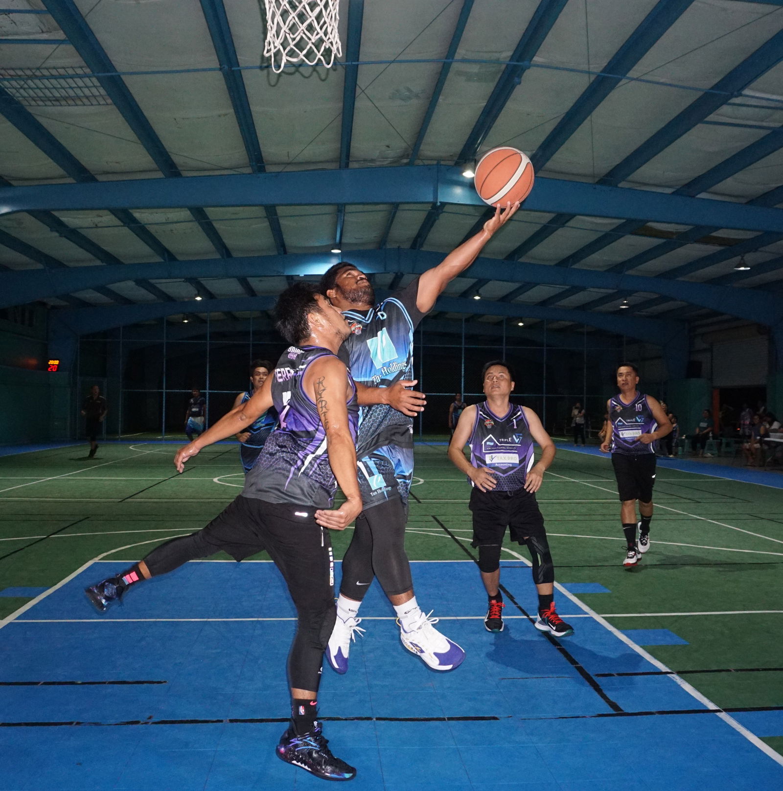 Tan Holdings' Ben William extends for the left-hand finish during a Legends Sports Association Invitational Basketball League Season 2 game at the TSL Sports Complex on Saturday. 