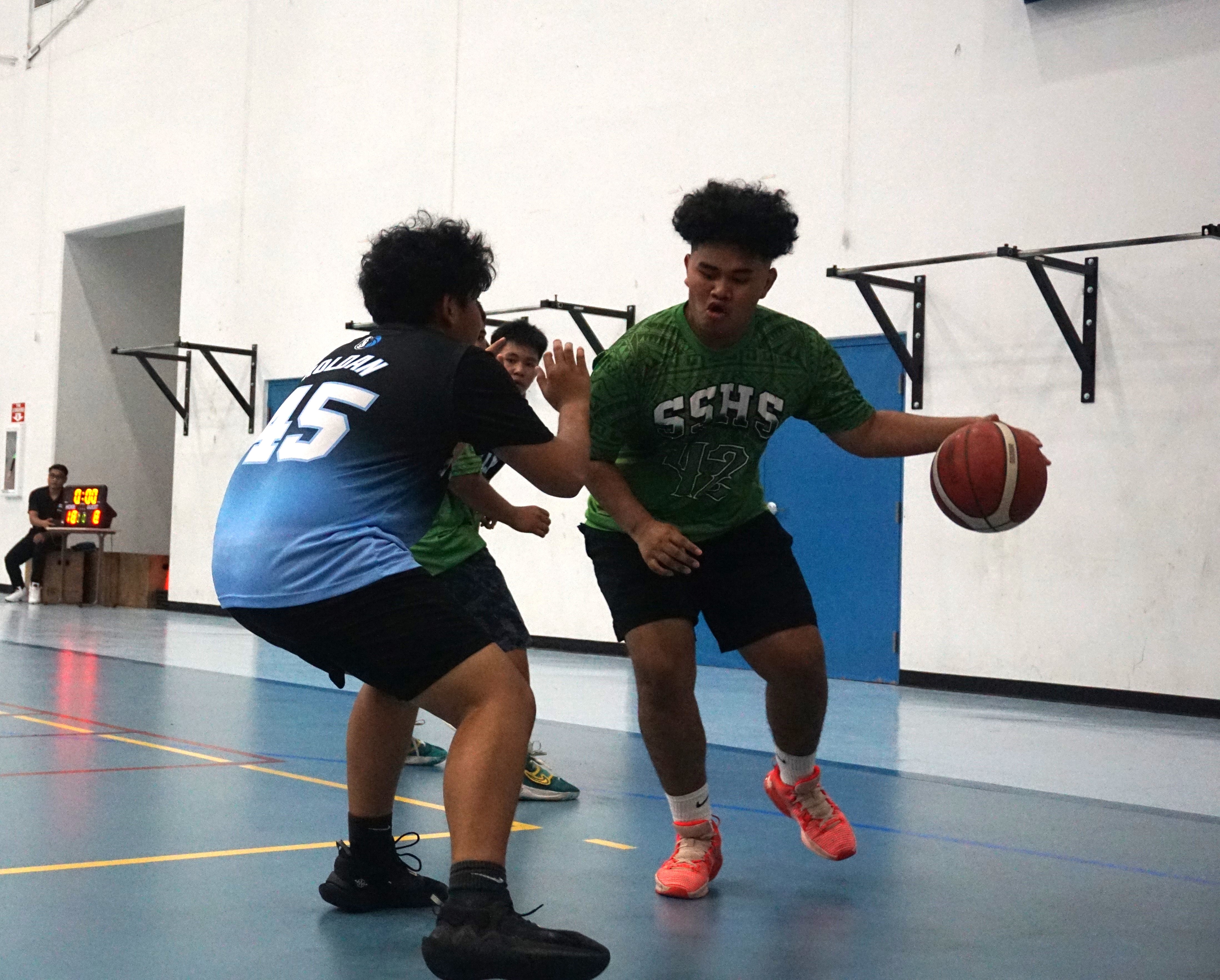 SSHS JV's Jayden Defang attempts to drive past a Tinian JV defender during a boys high school division game of the IT&E Interscholastic Basketball League at the MHS gym on Saturday.
