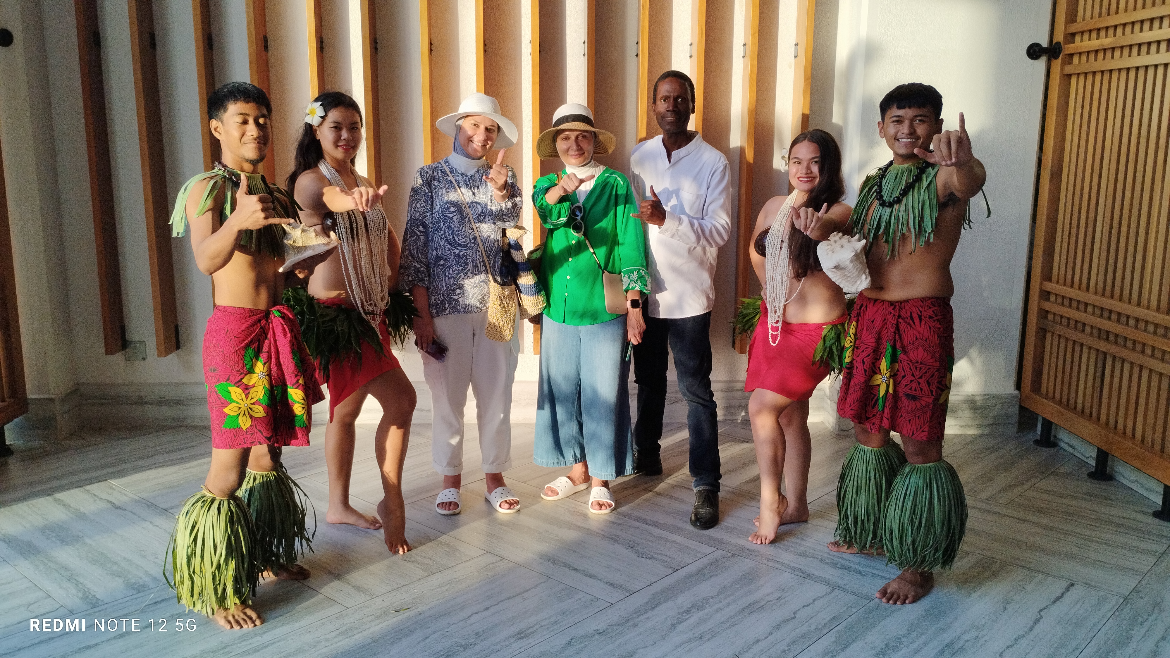 Wesam, 3rd left, and Weam Behbehani, 4th left, of Kuwait pose with author Walt Goodridge and cultural dancers at the Crowne Plaza on Saipan.