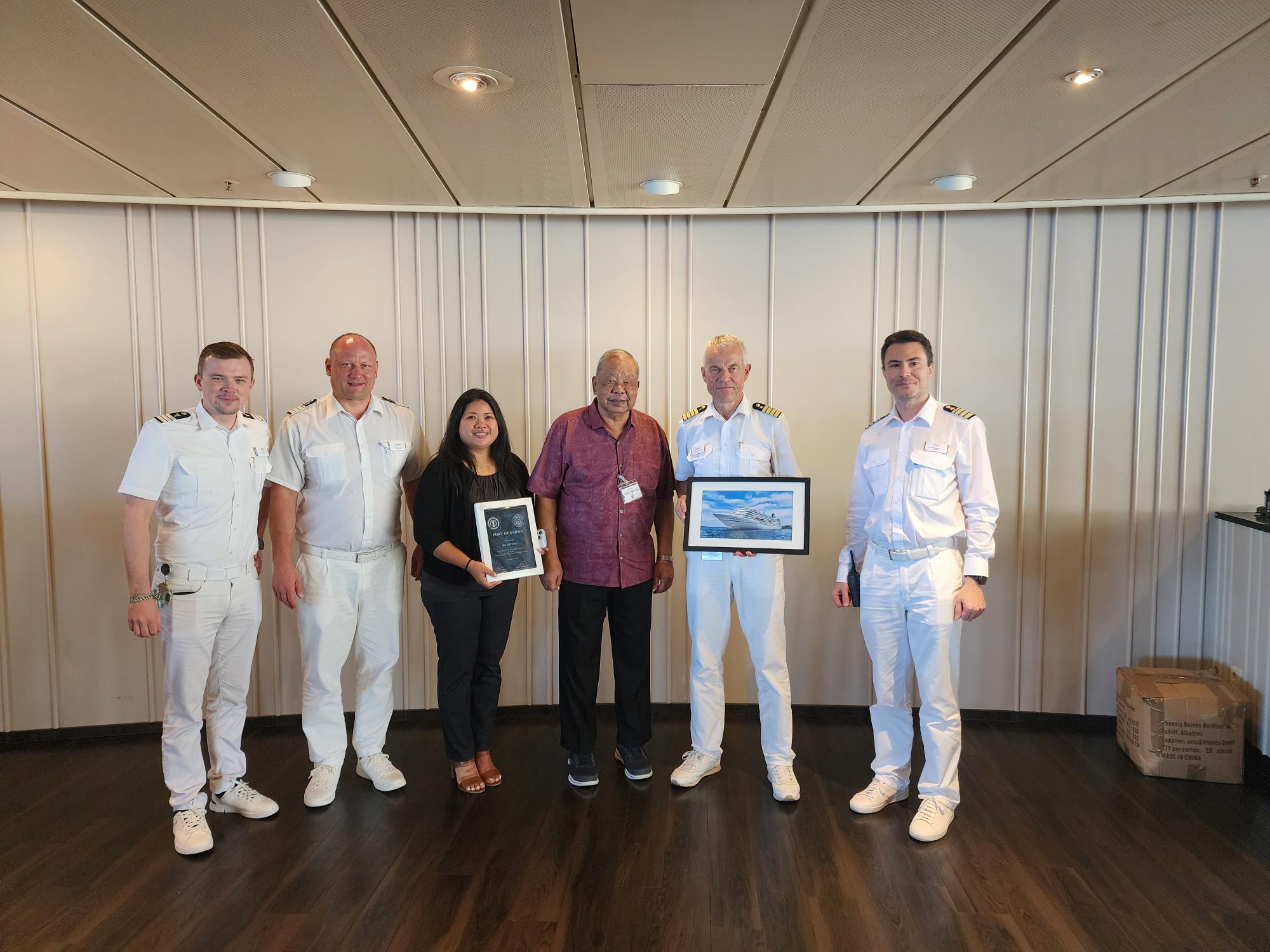 Acting Gov. David M. Apatang welcomes MS Artania Captain Burkhard Mueller and his officers. With Apatang is Commonwealth Ports Authority ports manager Jerra Cing who exchanged souvenirs with the visitors.