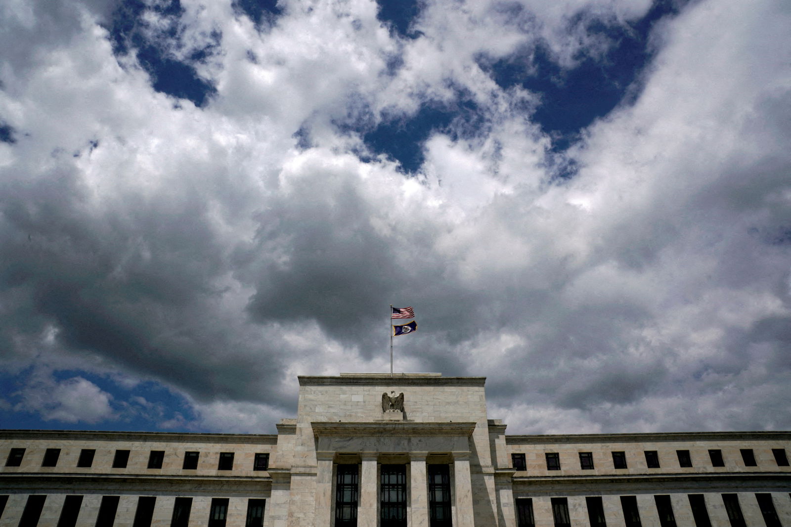 Flags fly over the Federal Reserve building on a windy day in Washington, D.C., May 26, 2017.