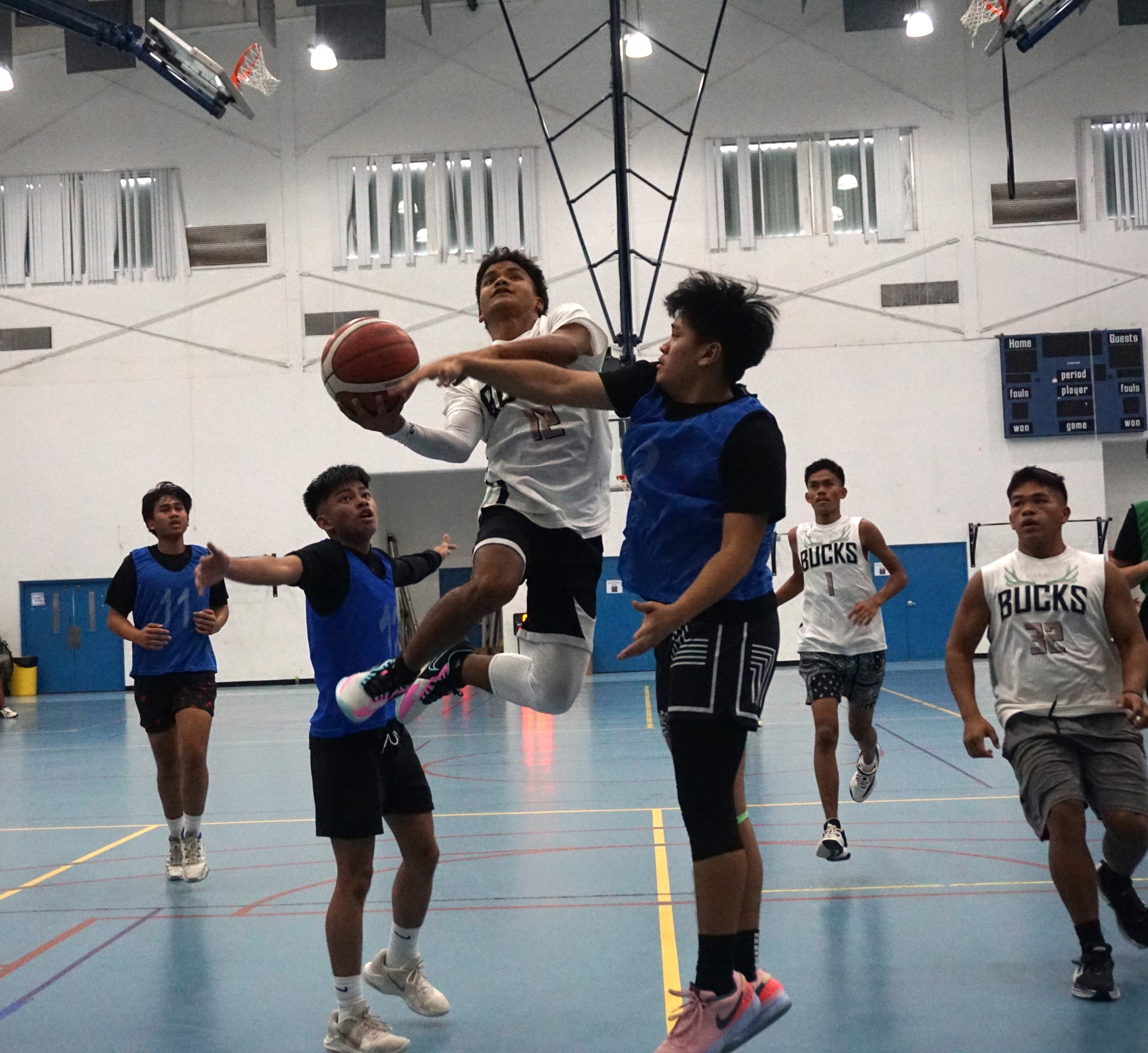 Rota’s Dr. Rita Hocog Inos Jr./Sr. High School's Ryan Manglona gets fouled as he goes up for the finish during a game against Marianas High School in the boys high school division of the IT&E Interscholastic Basketball League SY23-24 at the MHS gym on Saturday.