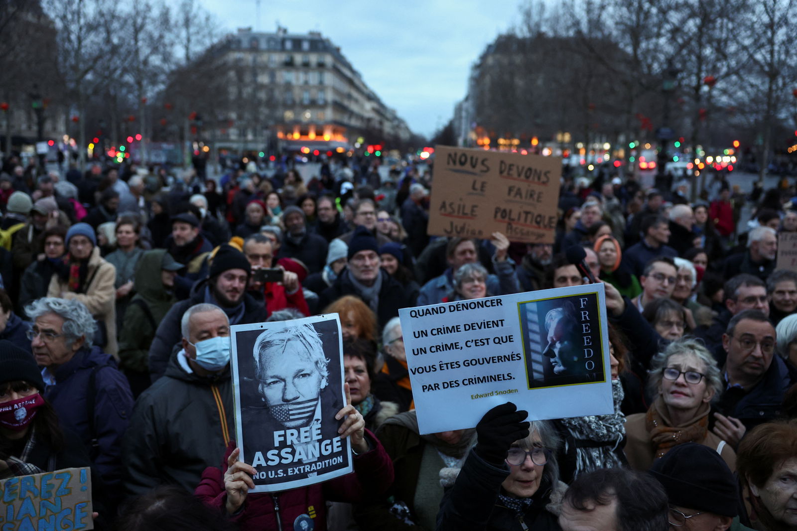 People hold banners as they gather in support of WikiLeaks founder Julian Assange at the Place de la Republique in Paris, on the day Assange appeals in a British court against his extradition to the United States, in Paris, France, February 20, 2024. 