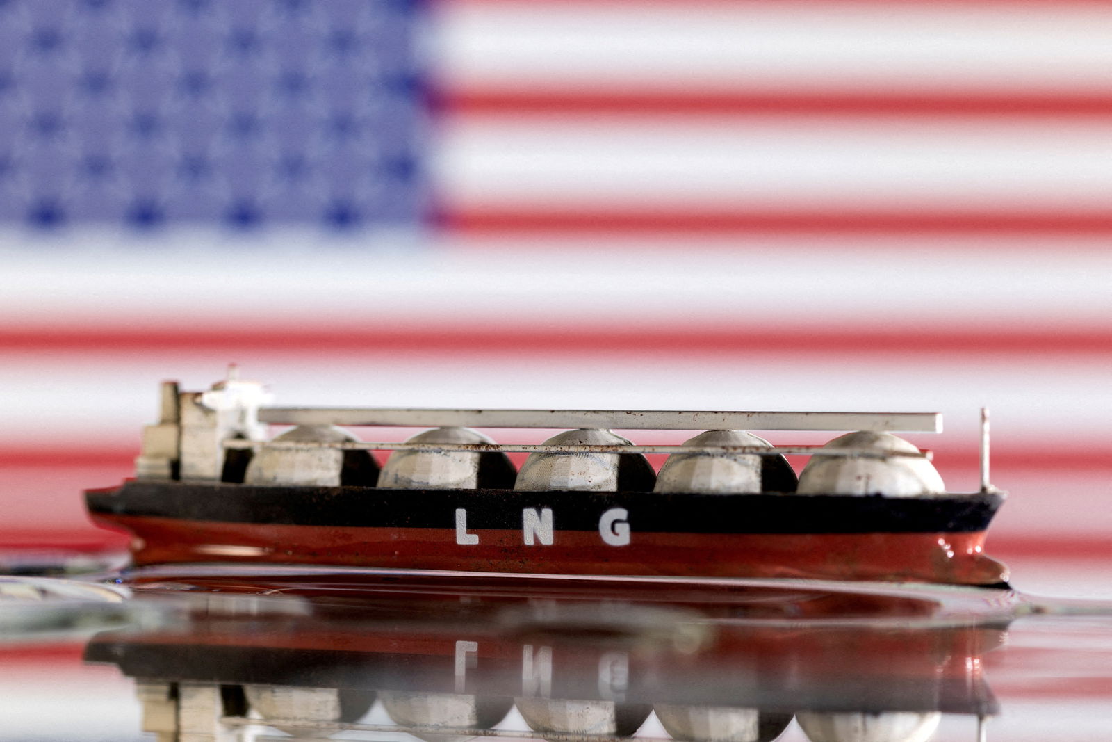 Model of LNG tanker is seen in front of the U.S. flag in this illustration taken May 19, 2022. 