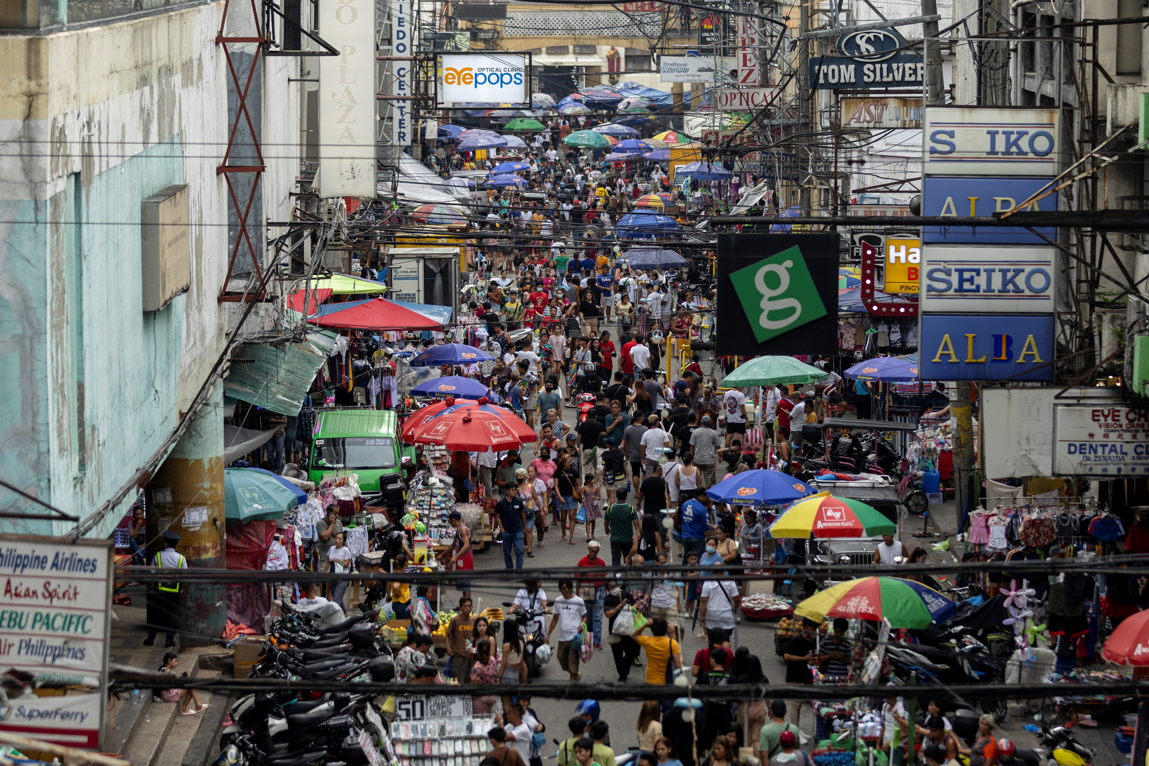 People walk along a street market in Quiapo, in Manila, Philippines, July 11, 2023. 