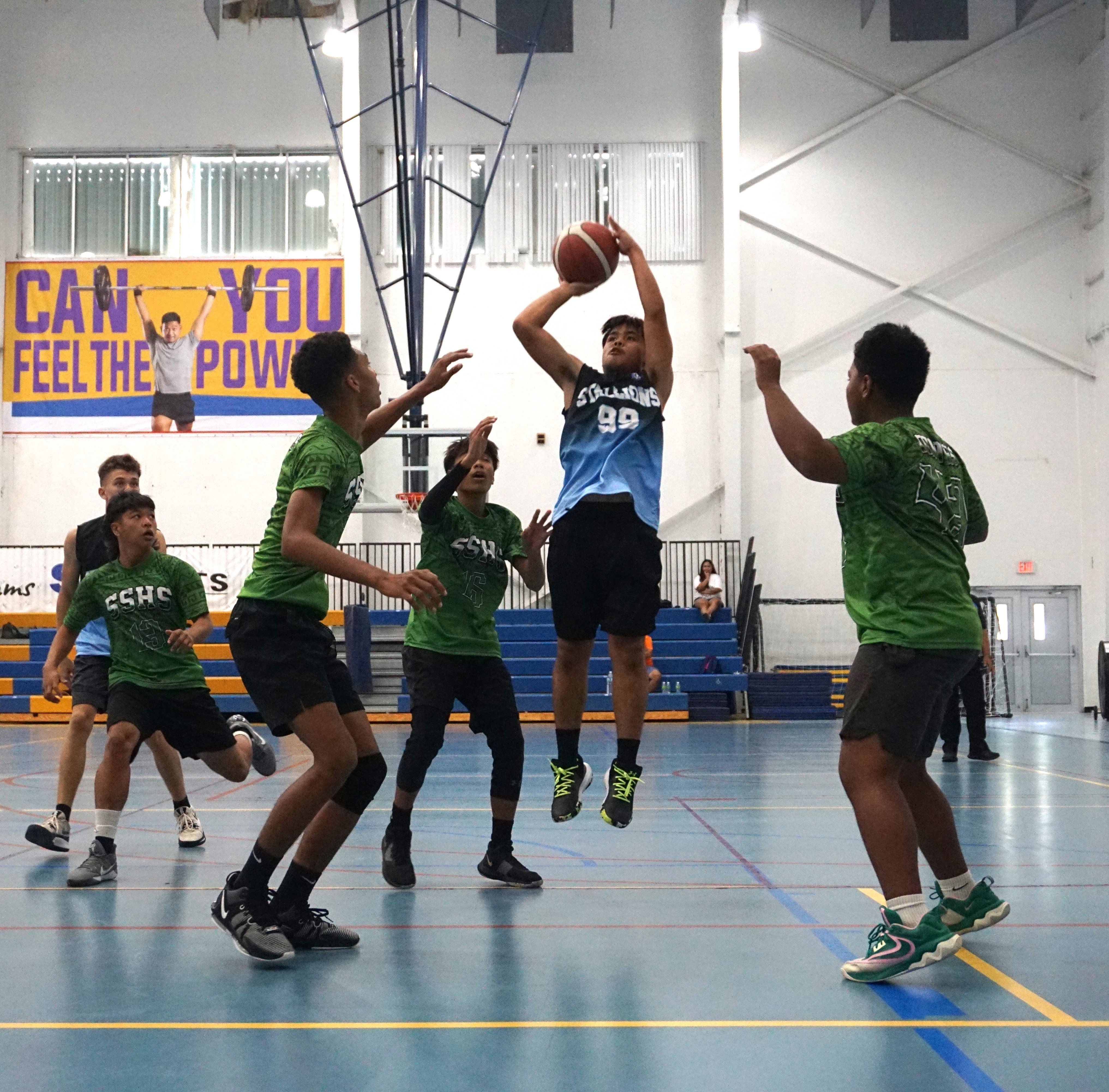 Tinian JV's Joe John Reyes pulls up for the shot against three SSHS JV defenders during a boys high school division game of the IT&E Interscholastic Basketball League at the MHS gym on Saturday.
