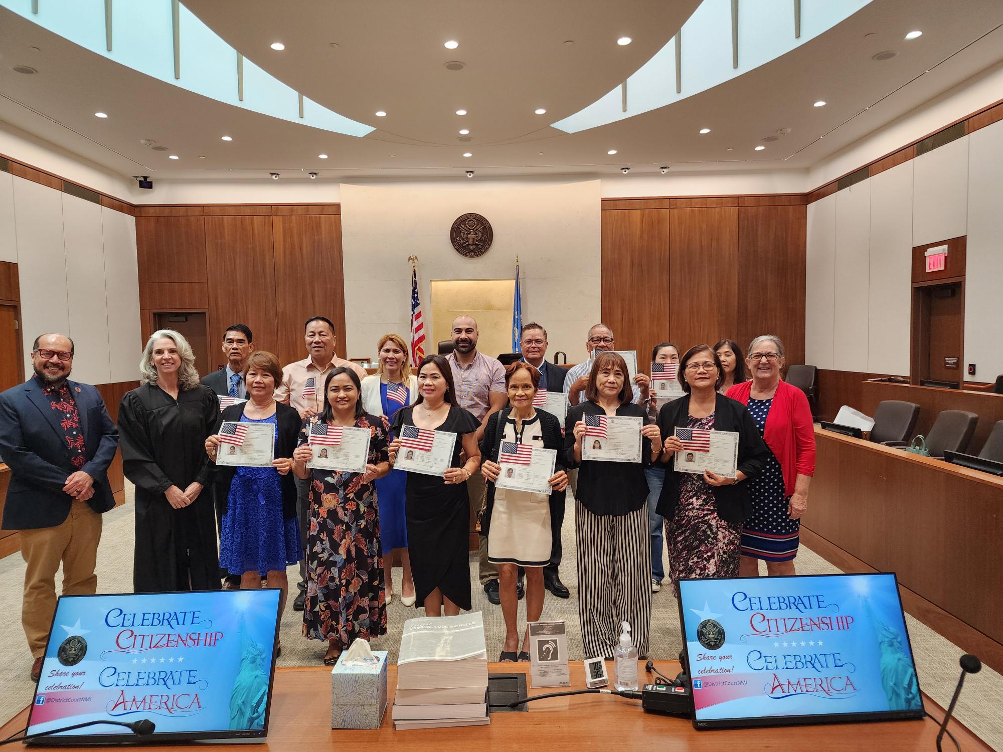 Northern Marianas College President Galvin Deleon Guerrero and Magistrate Judge Heather Kennedy poses with the 14 new U.S. citizens Thursday at the District Court for the NMI. Also in photo: U.S. Citizenship and Immigrations Services Officer Patricia Phelan. 