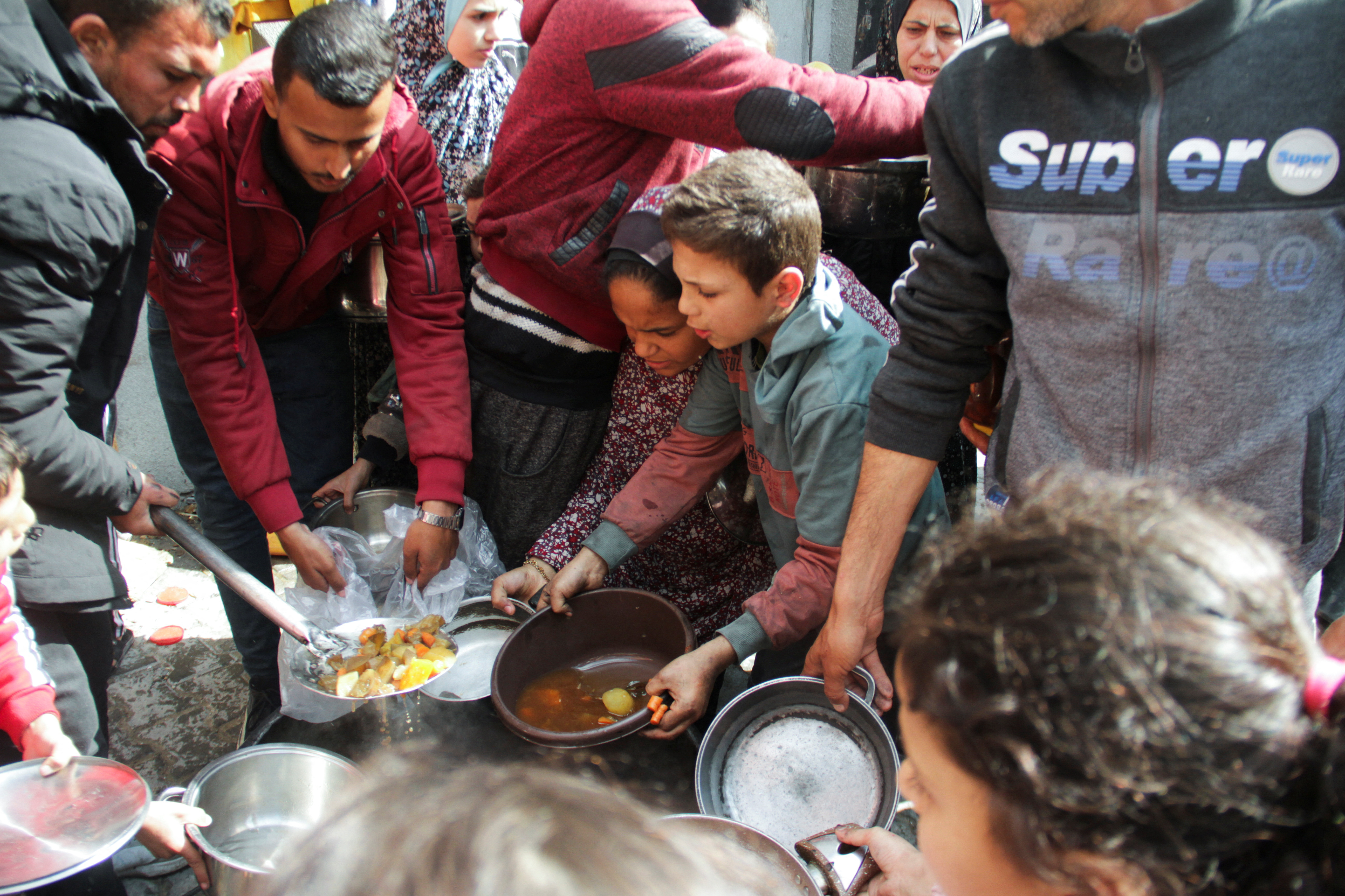 Palestinians gather to receive free food as Gaza residents face crisis levels of hunger, during the holy month of Ramadan, amid the ongoing conflict between Israel and Hamas, in Jabalia in the northern Gaza Strip March 19, 2024. 