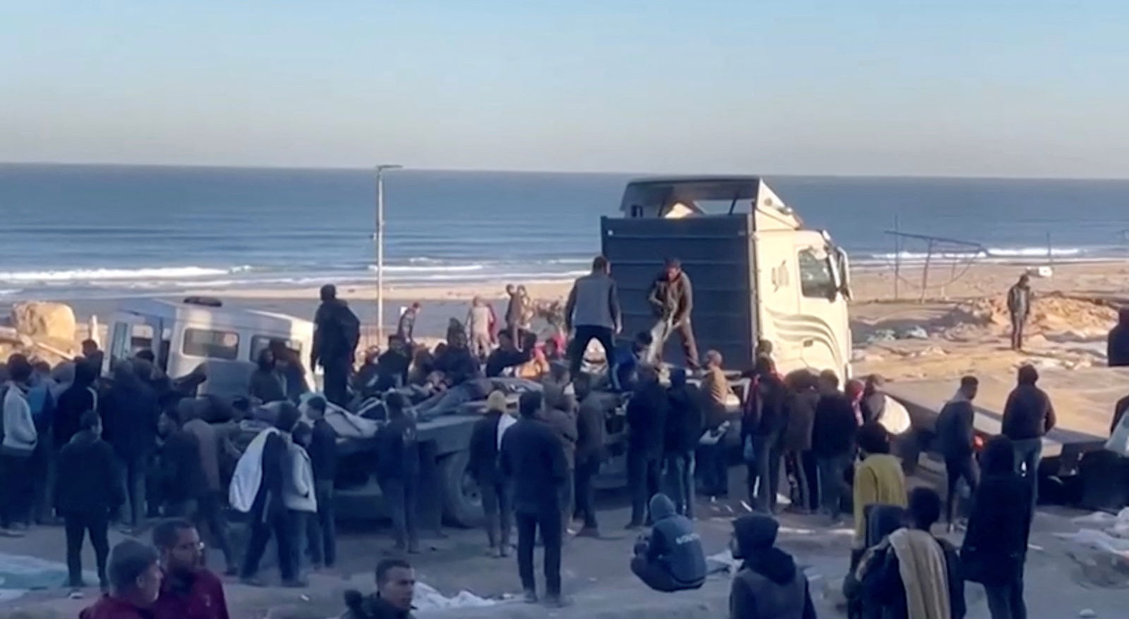 Palestinians transport casualties following what Palestinian health officials said was Israeli fire on people waiting for aid, in Gaza City, in this still picture taken from a video February 29, 2024. 