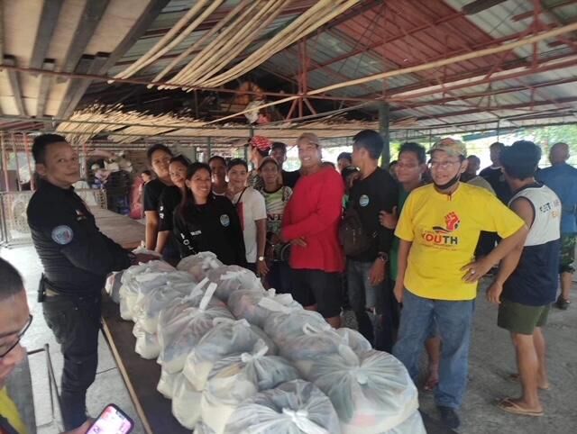Rey Elpuz, founder of Philippine Guardians Brotherhood Inc. and president of NYMWPS Zambales chapter, and PGBI Cainta chapter member Arnaldo Aljibe assist in giving out bags of groceries and rice to fisherfolk.