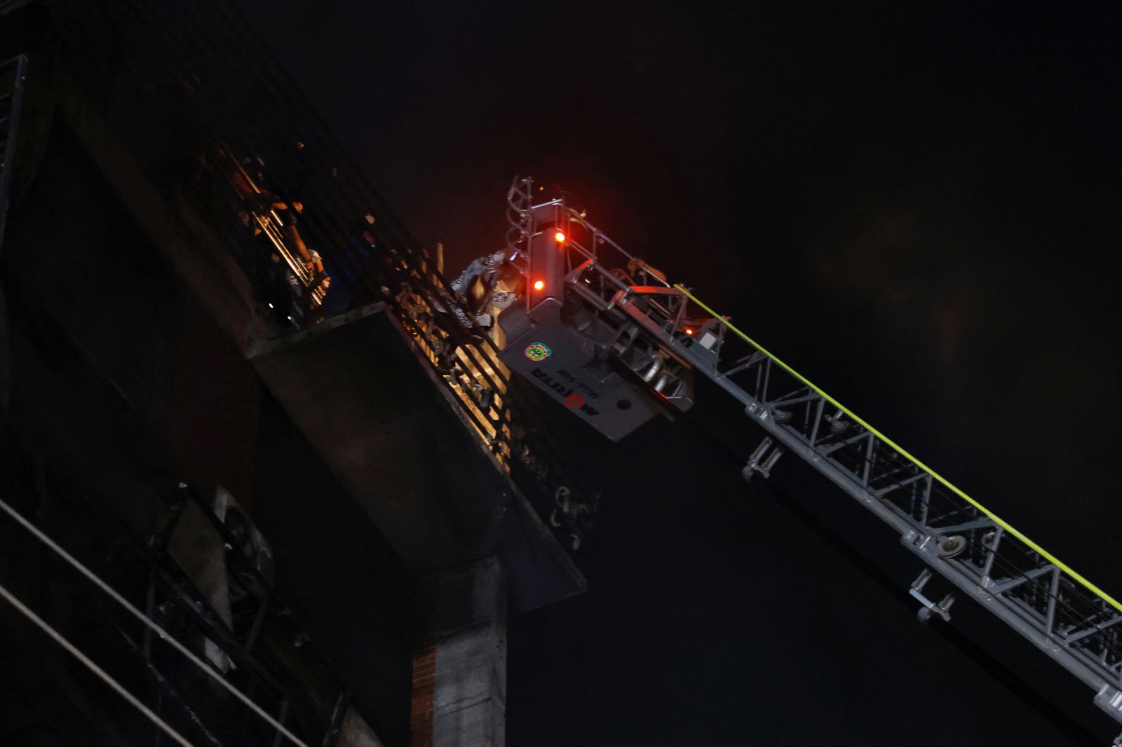 Firefighters rescue people from the roof after a fire broke out in a multi-storey building in Dhaka, Bangladesh, February 29, 2024. 