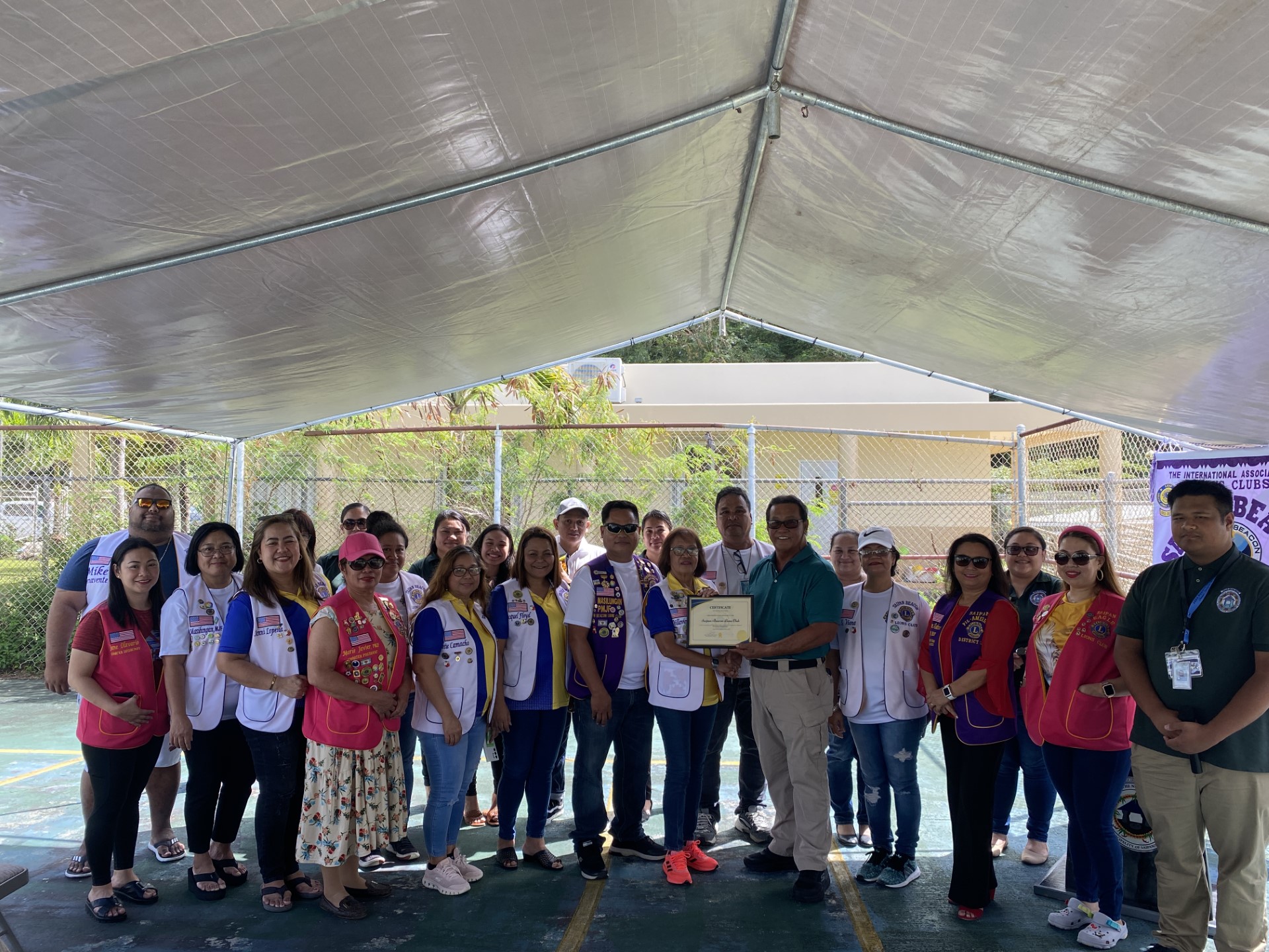 The Saipan Beacon Lions and Mayor RB Camacho pose for a photo at ceremony that formalized the civic organization’s “adoption” of the Chinatown basketball court on Monday.