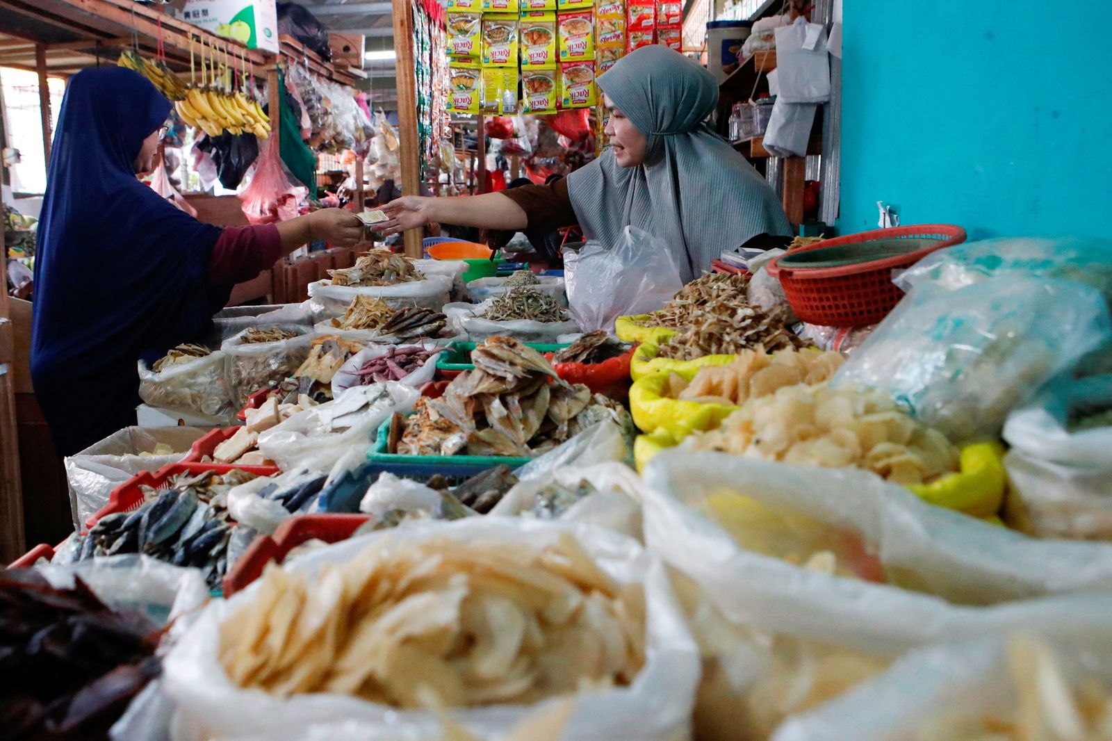 FILE PHOTO: A vendor serves a customer at a traditional market in Jakarta, Indonesia, January 2, 2023. 