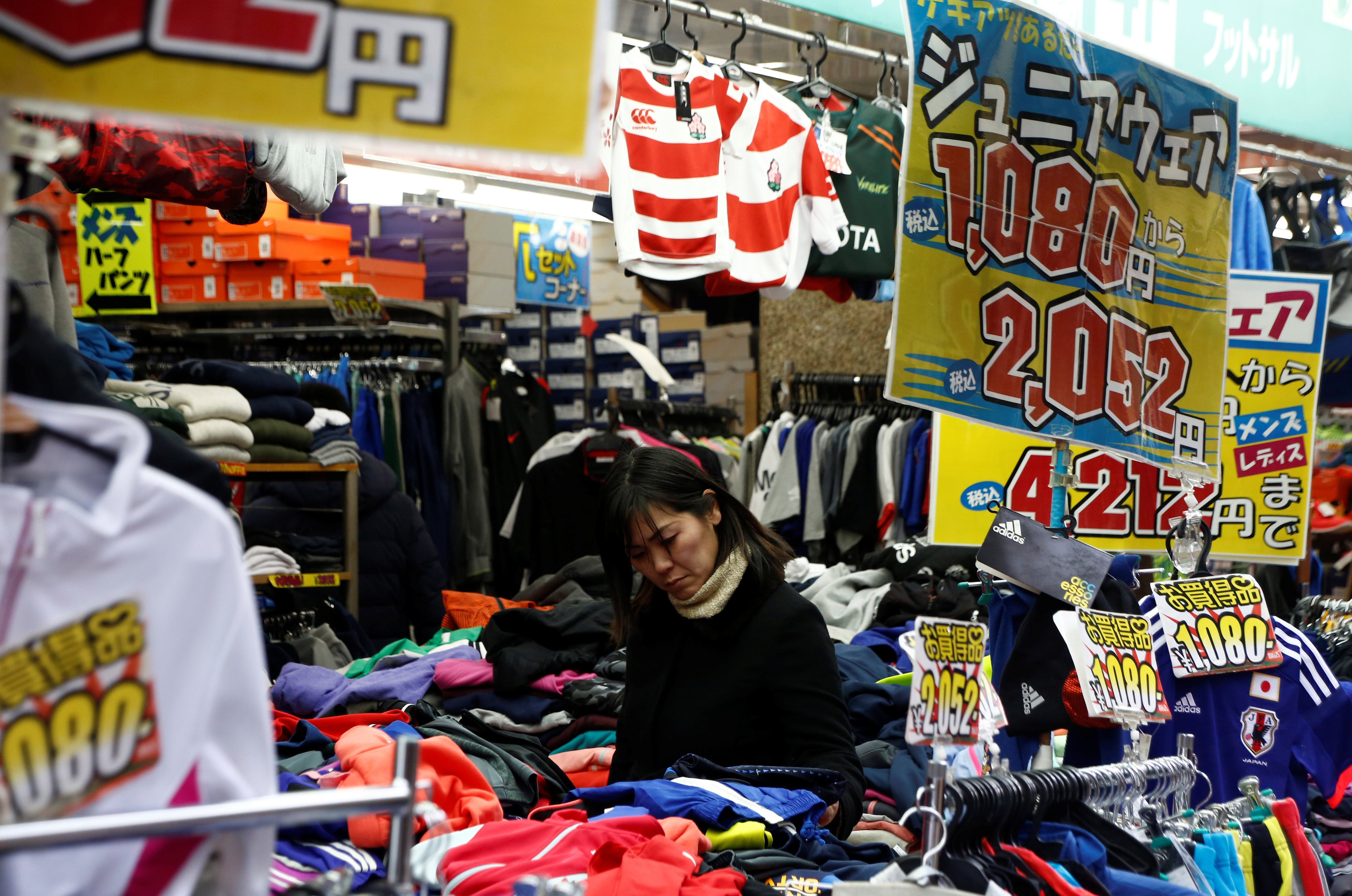 FILE PHOTO: A woman chooses clothes at a shop in Tokyo, Japan, January 23, 2017. Picture taken on January 23, 2017. 