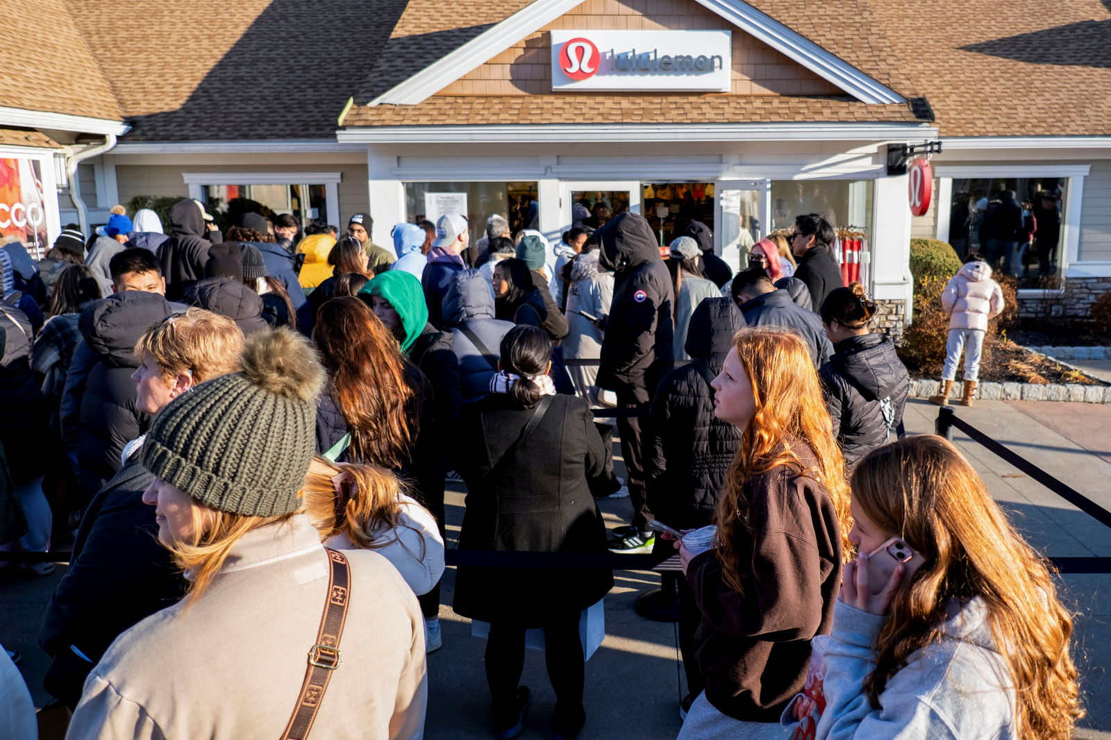 FILE PHOTO: Black Friday shoppers stand in line for a Lululemon store as retailers compete to attract shoppers and try to maintain margins on Black Friday, one of the busiest shopping days of the year, at Woodbury Common Premium Outlets in Central Valley, New York, U.S. November 24, 2023. 
