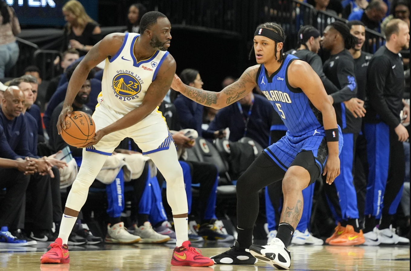 Golden State Warriors forward Draymond Green (23) looks for an opening as Orlando Magic forward Paolo Banchero (5) defends during the first half of an NBA game Wednesday, March 27, 2024 in Orlando, Fla.
