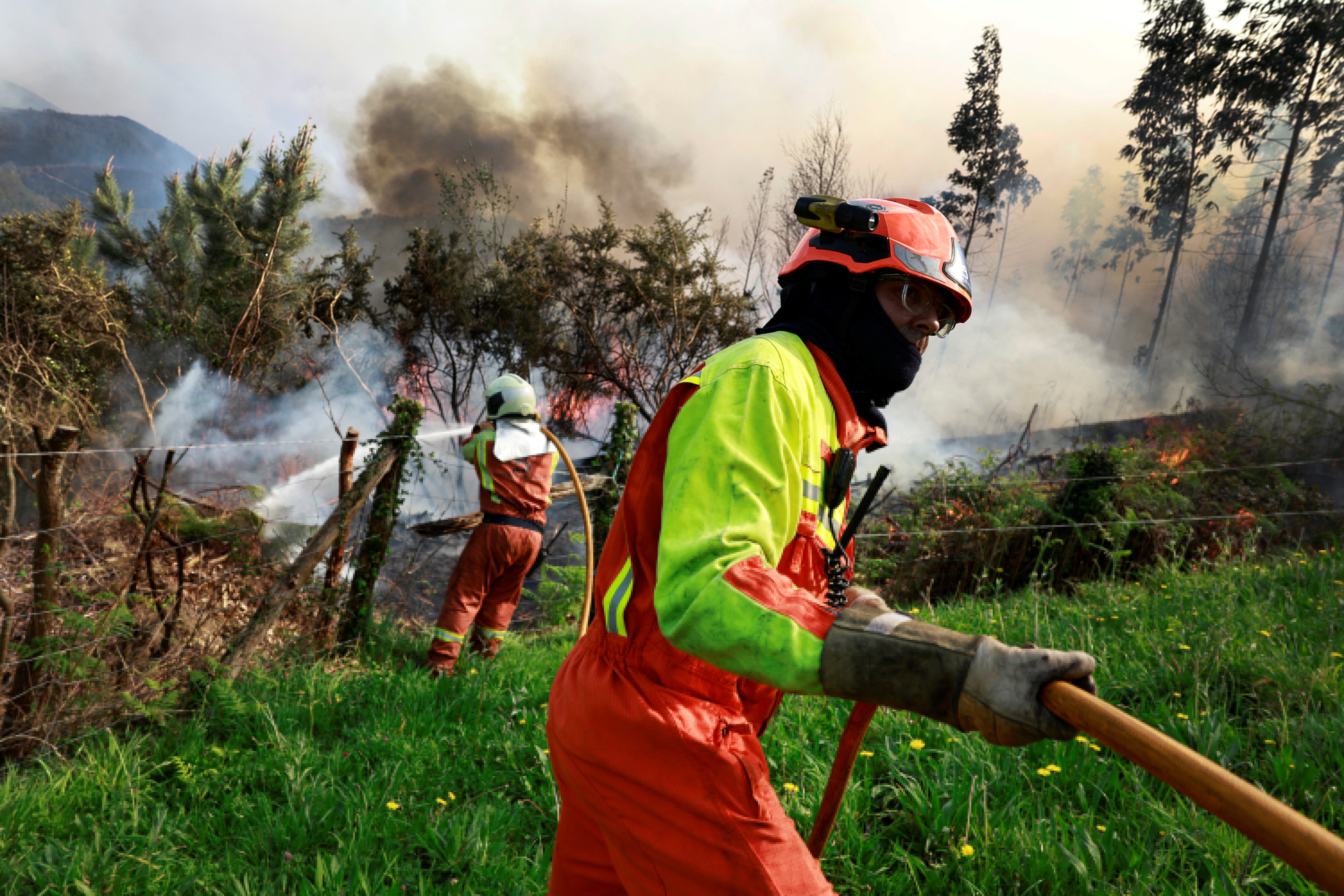Firefighters tackle a blaze near the village of Setienes during an outbreak of wildfires in northern Spain's Asturias region, March 31, 2023. 