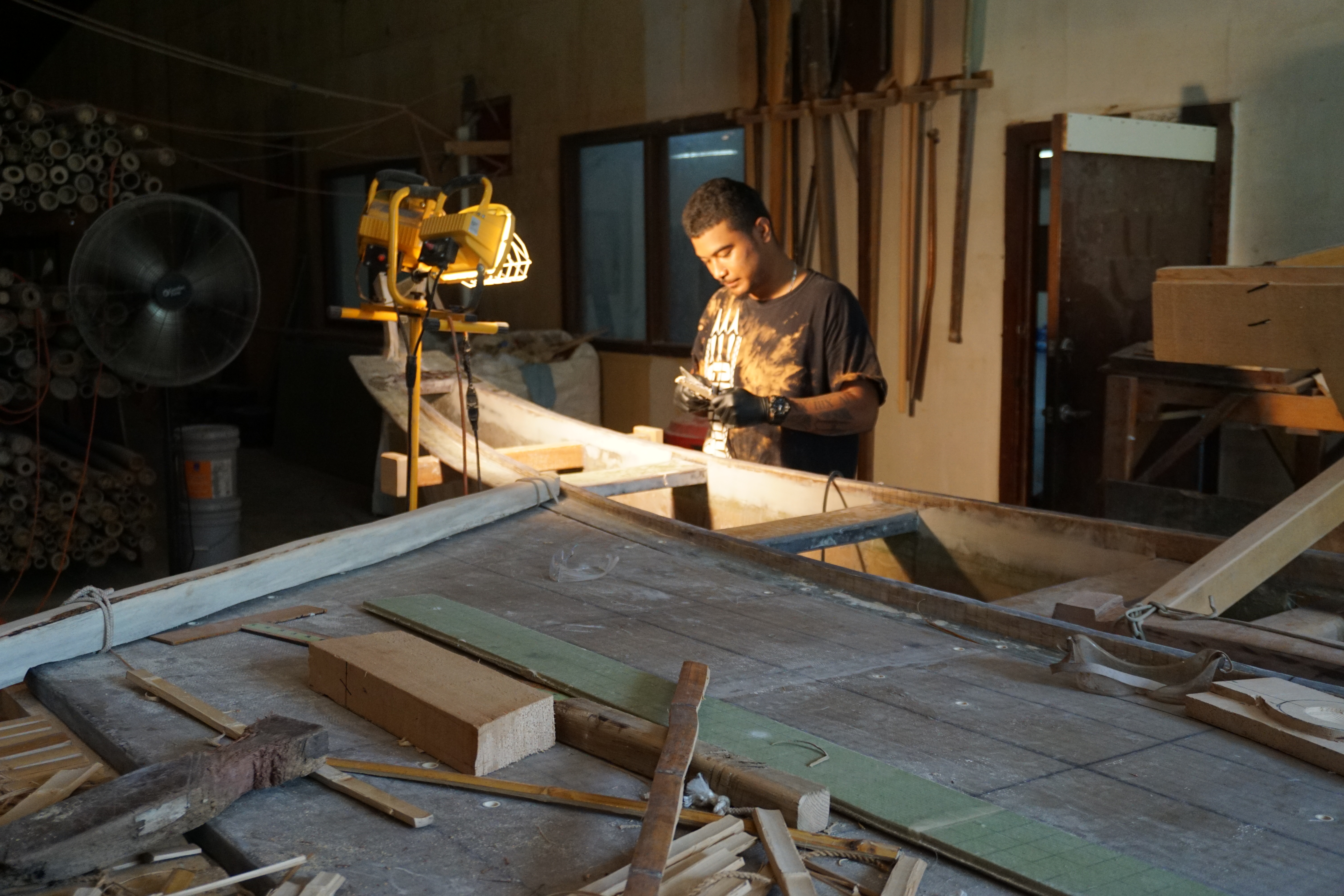 Lolo Benito works on Mikaela, which may be the first Carolinian style canoe made partially with fiberglass.