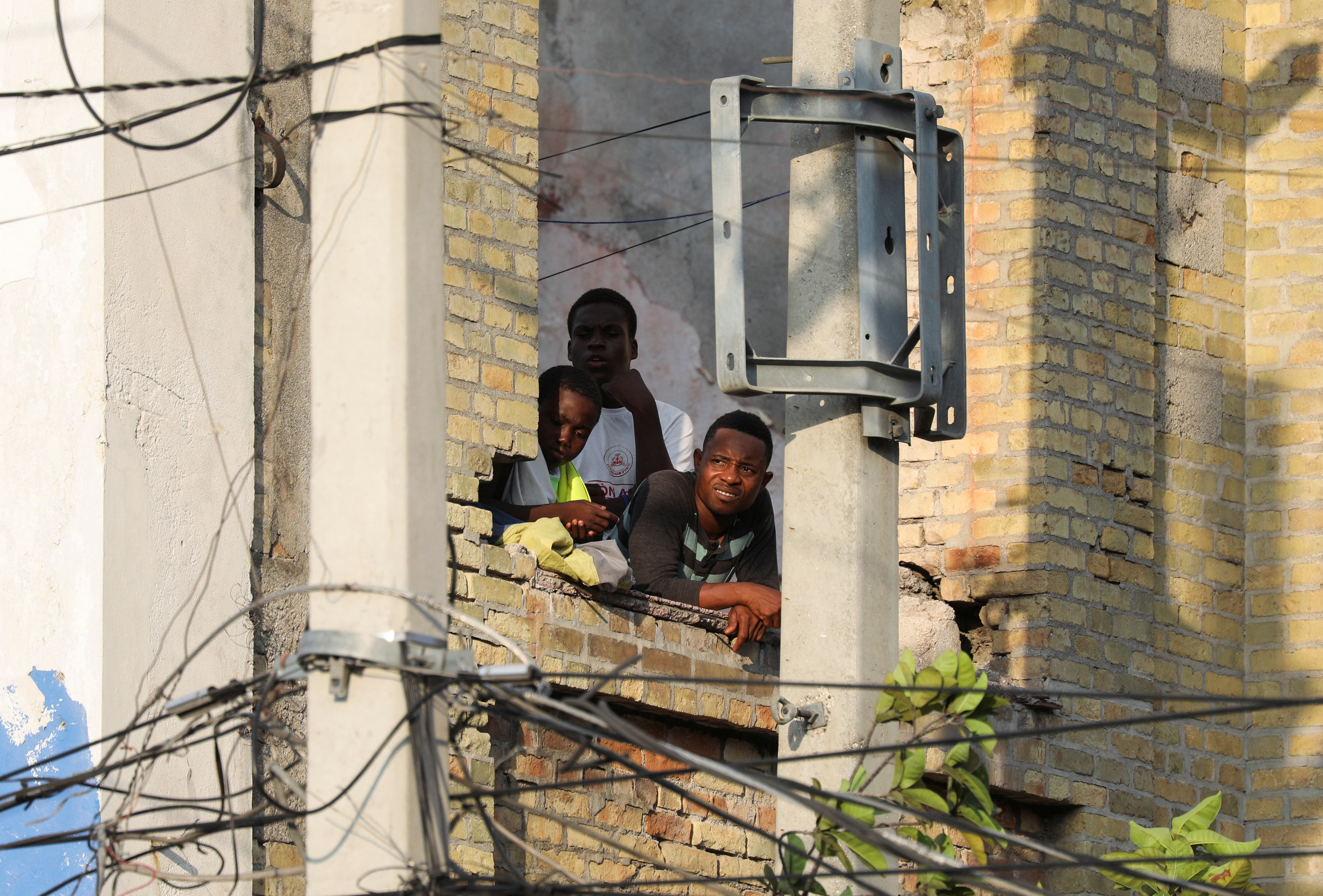 People watch a fight between gangs and the police near the National Palace, in Port-au-Prince, Haiti March 21, 2024. 