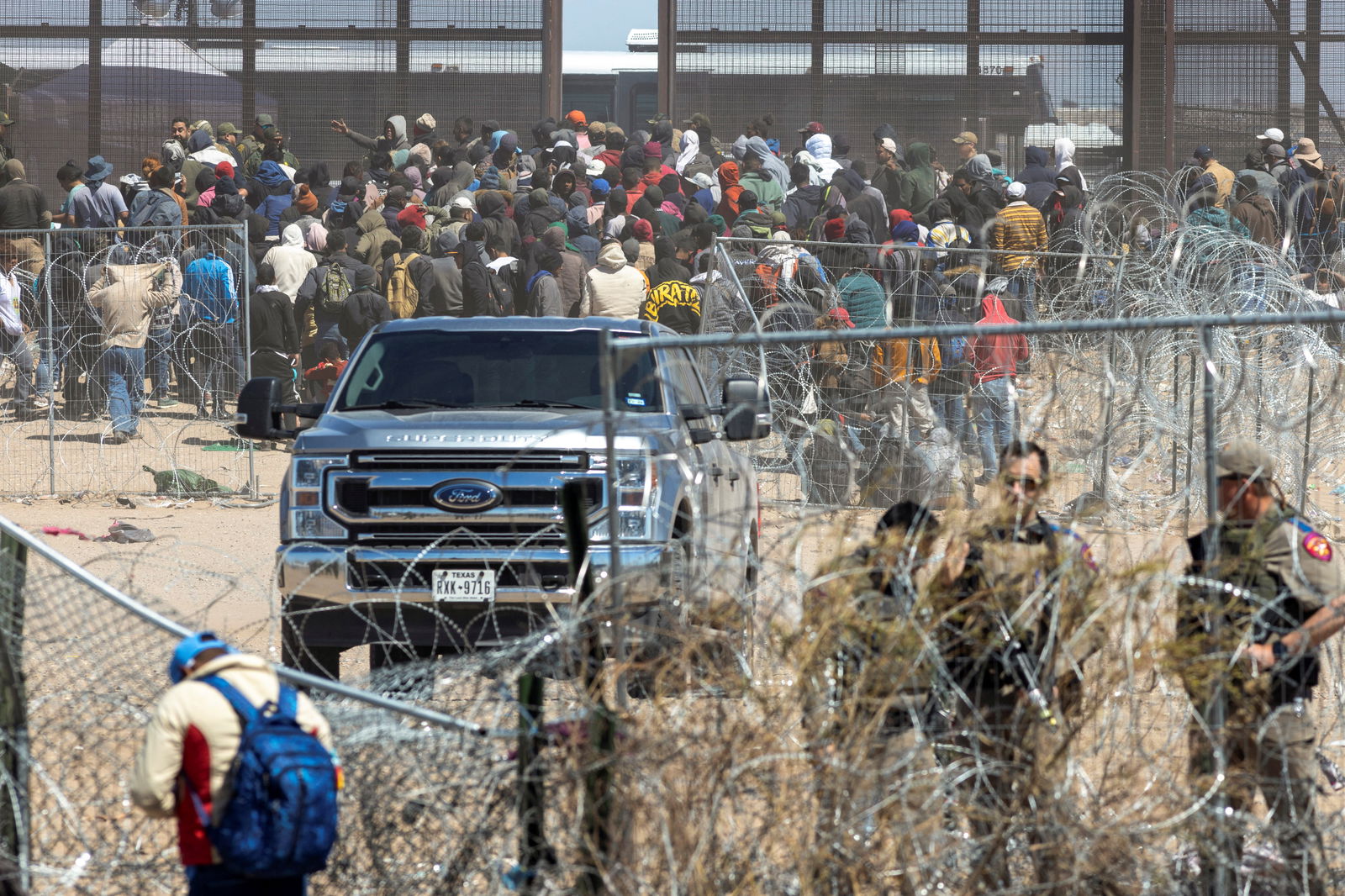 Migrants gather near the border fence after they forced their way by breaking through razor wire and a fence, as SB 4 law that would empower law enforcement authorities in the state to arrest people suspected of illegally crossing the U.S.-Mexico border was temporarily blocked, as seen from Ciudad Juarez, Mexico, March 21, 2024. 