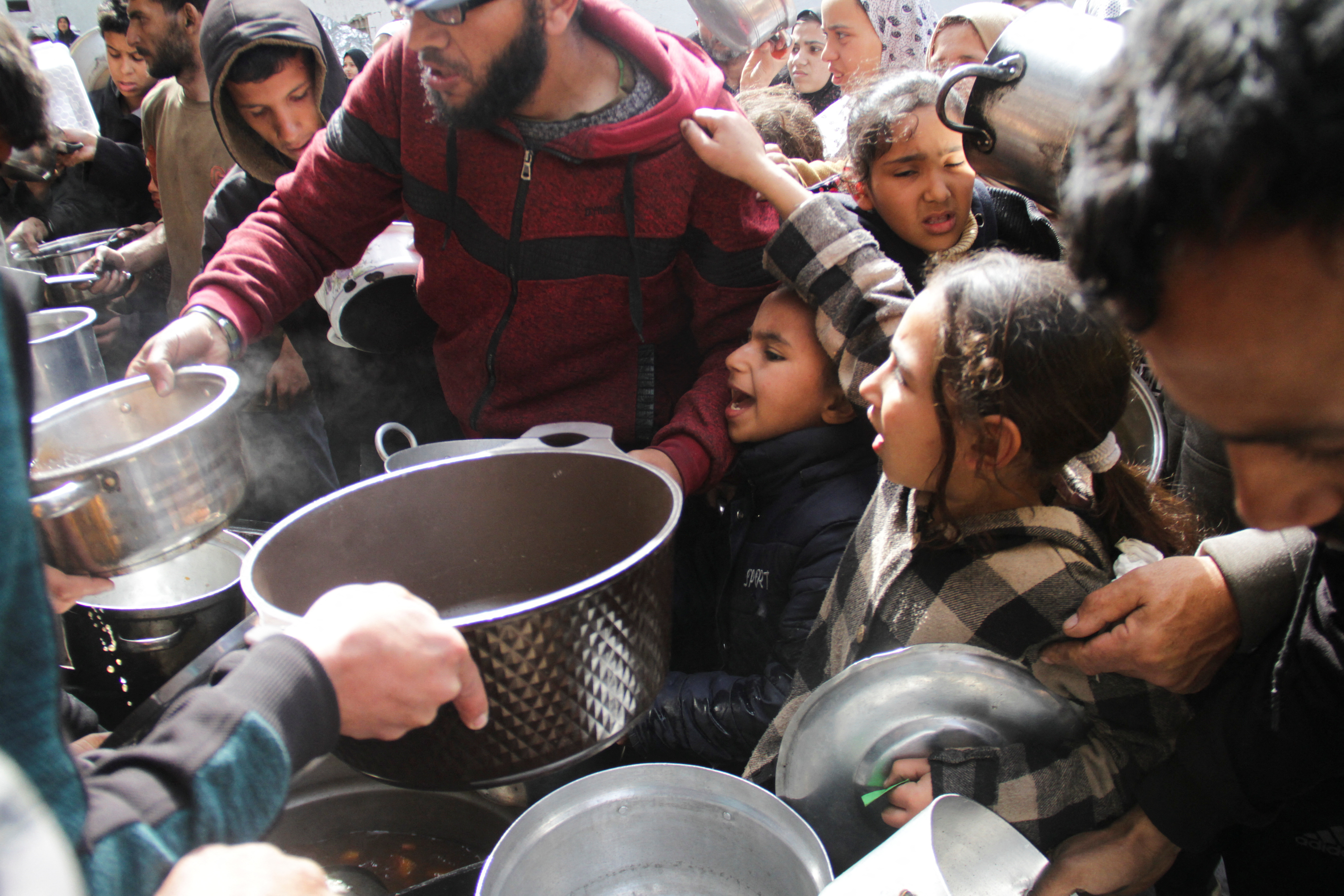 Palestinians gather to receive free food as Gaza residents face crisis levels of hunger, during the holy month of Ramadan, amid the ongoing conflict between Israel and Hamas, in Jabalia in the northern Gaza Strip March 19, 2024. 