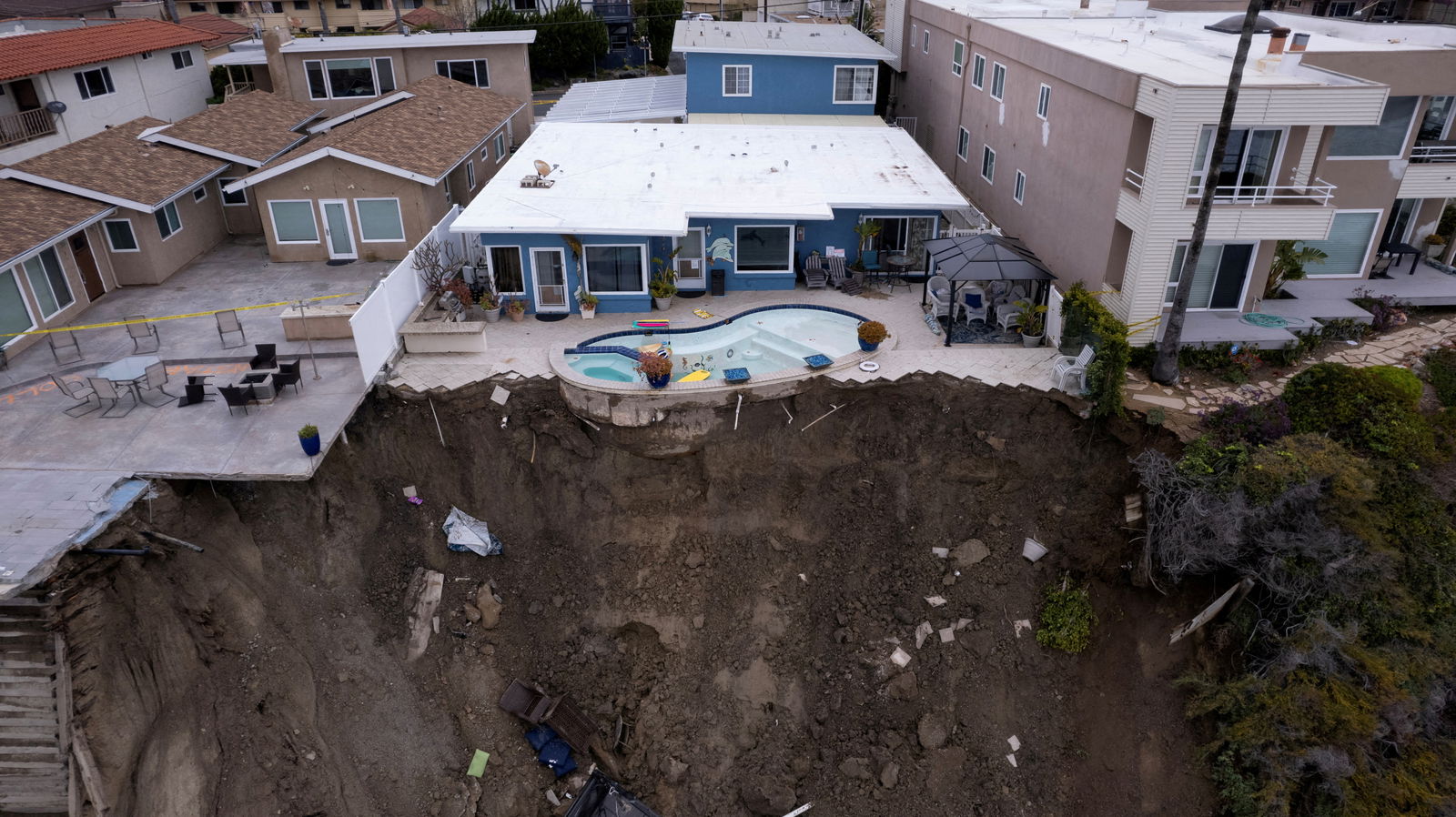 FILE PHOTO: A backyard pool is left hanging on a cliffside after torrential rain brought havoc on the beachfront town of San Clemente, California, U.S. March 16, 2023. 