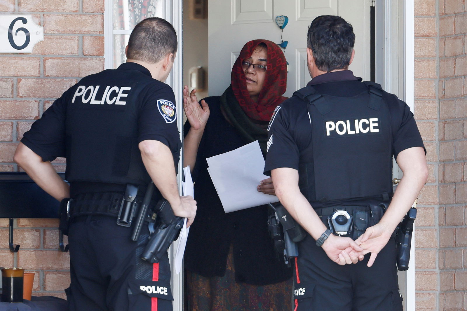 Ottawa Police Service officers speak to neighbors after four children and two adults were found dead inside a nearby home in the Ottawa suburb of Barrhaven, Ontario, Canada March 7, 2024. 