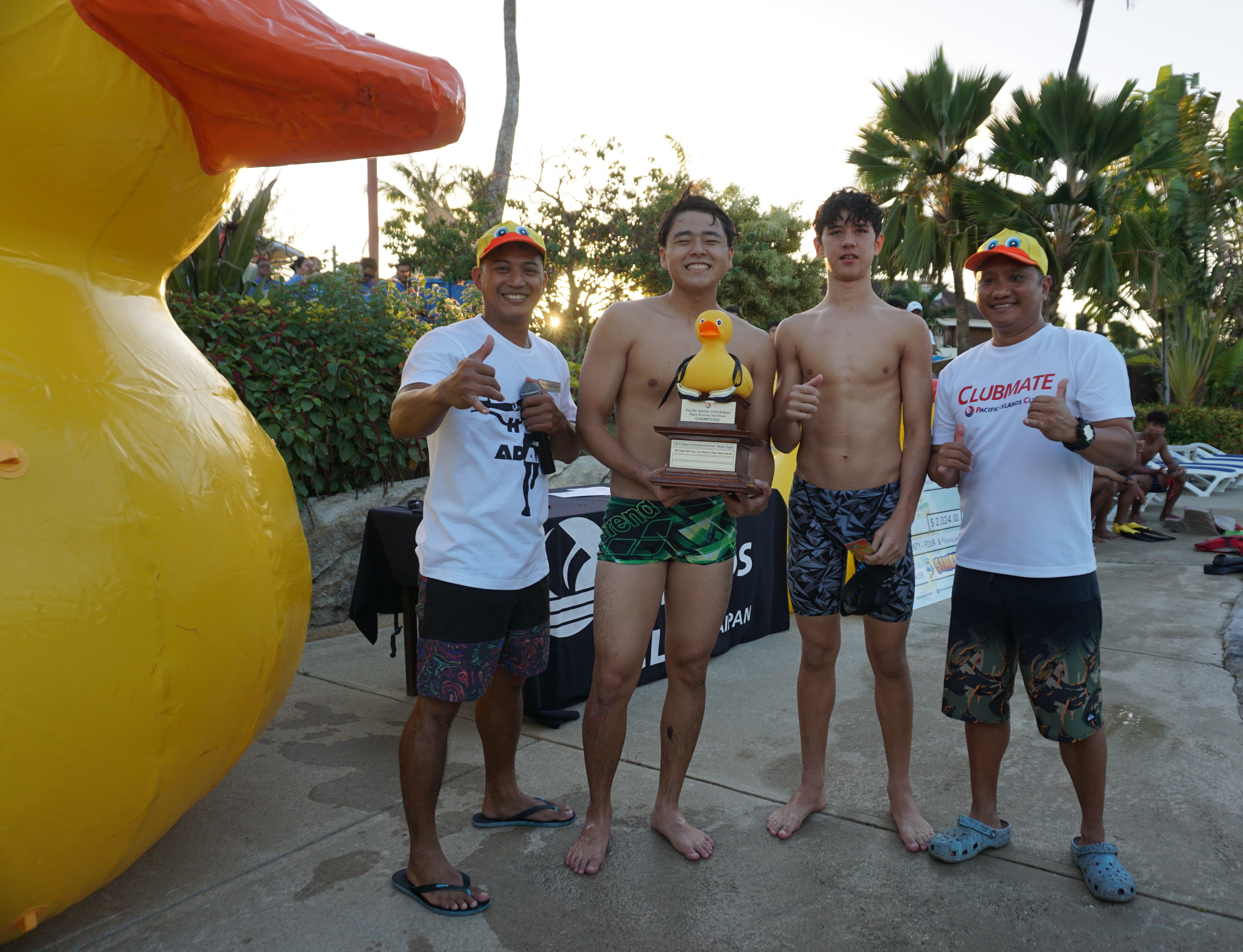 Human duck race winners Taiyo Akimaru and Michael Miller with the perpetual trophy pose for a photo with Dennis Tababa, director of sports, entertainment and activities at the Pacific Islands Club Saipan, and Reymark Castro, PIC’s animations and events manager.